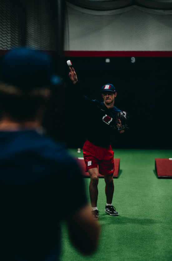 Players playing catch on turf inside the Northwest Nationals facility in Beaverton