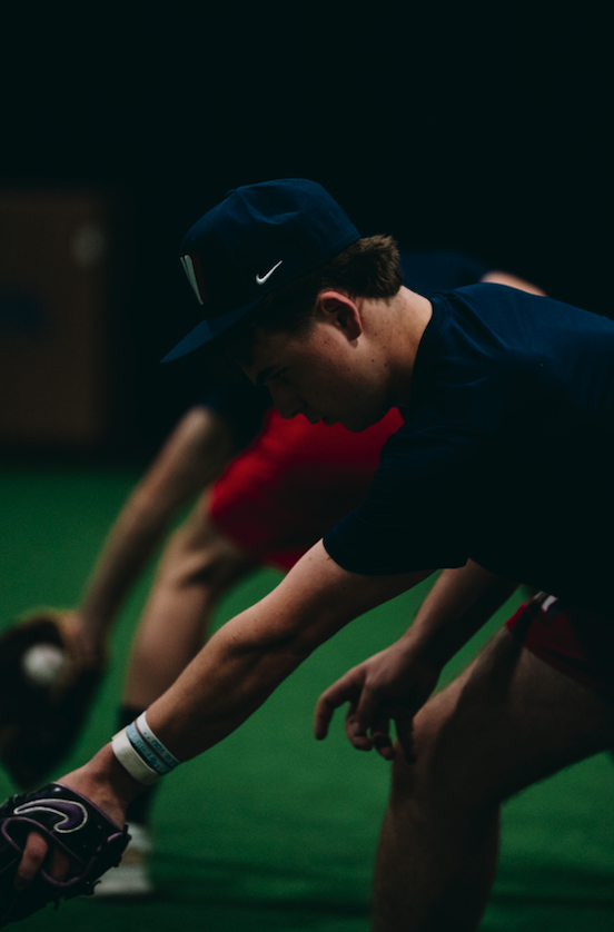 Player bending low to field a ground ball during baseball training