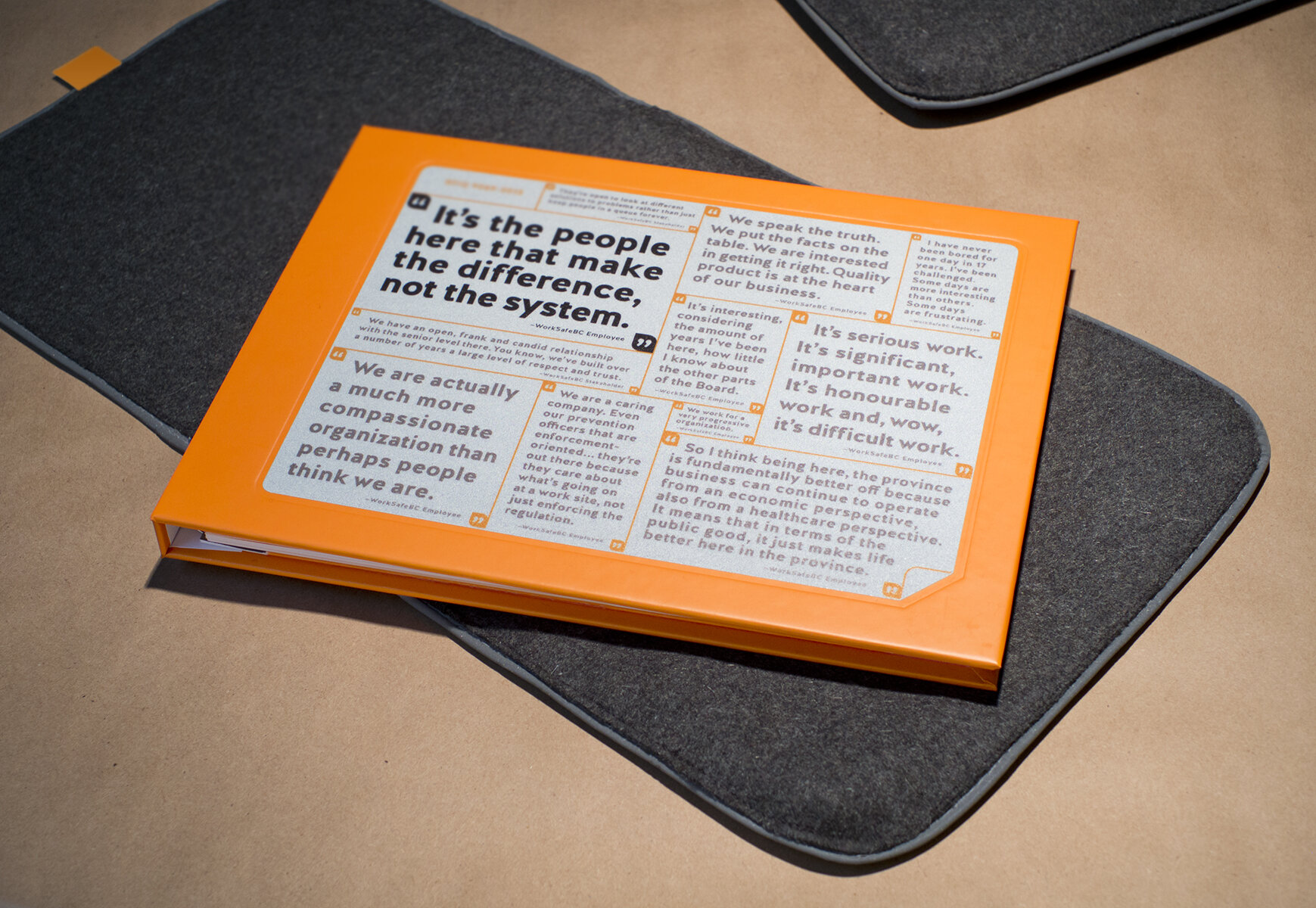  Orange hardcover brochure layed on fleece sleeve 