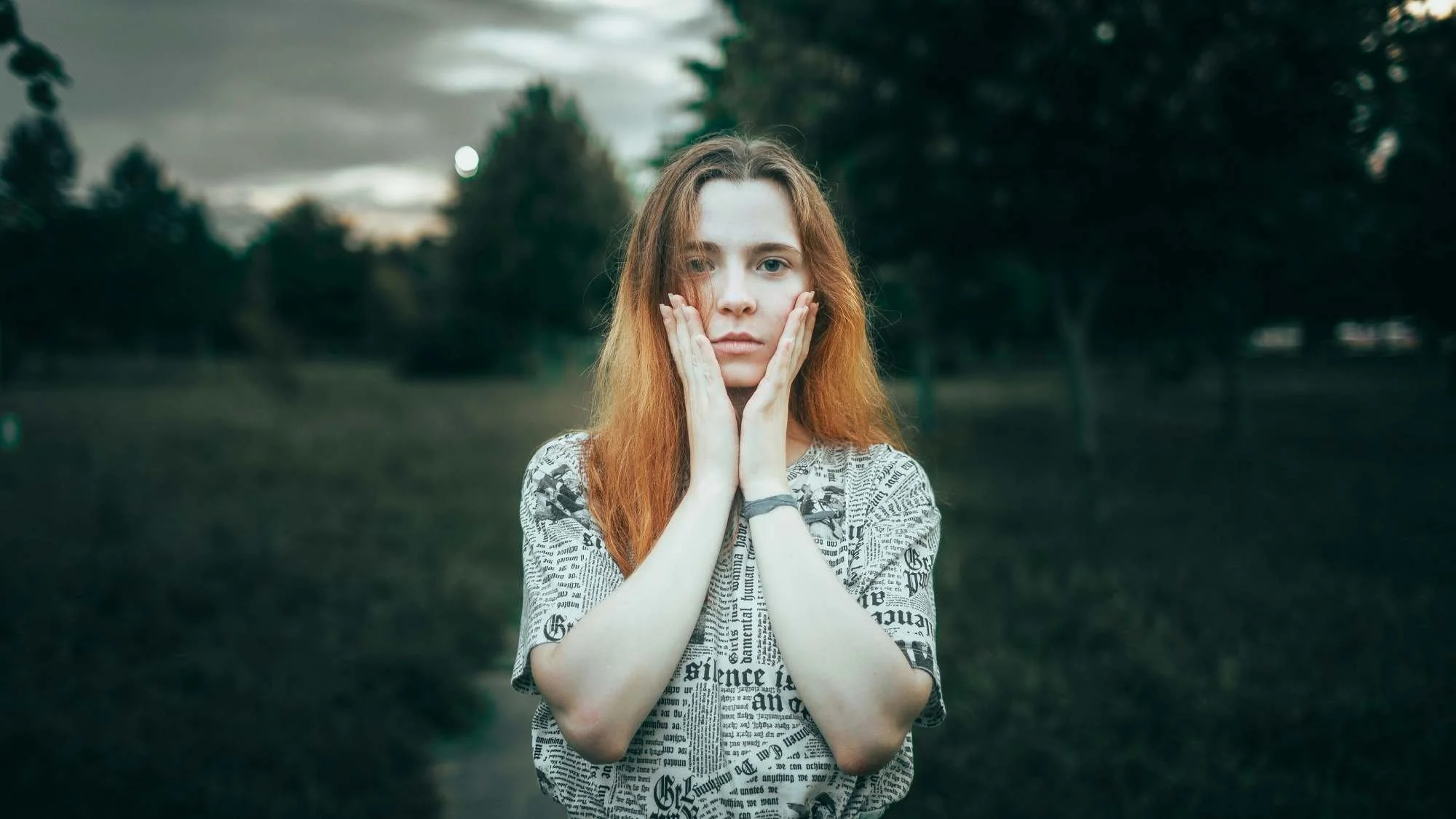 Persoon met handen tegen het gezicht, in een moment van innerlijke spanning en reflectie
