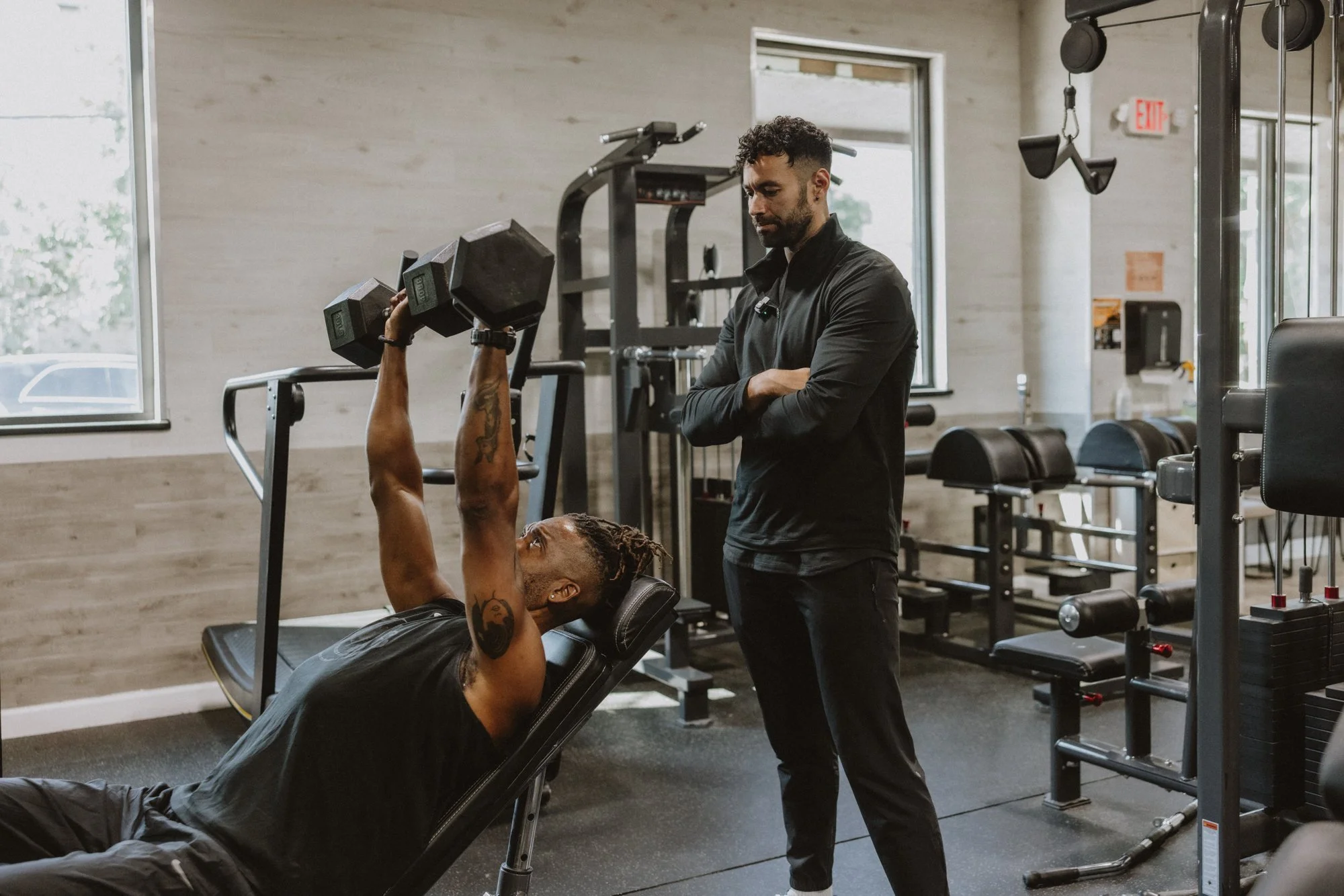 Dr. Luke Apple coaching a client through a dumbbell press at SOMO Performance in Atlanta