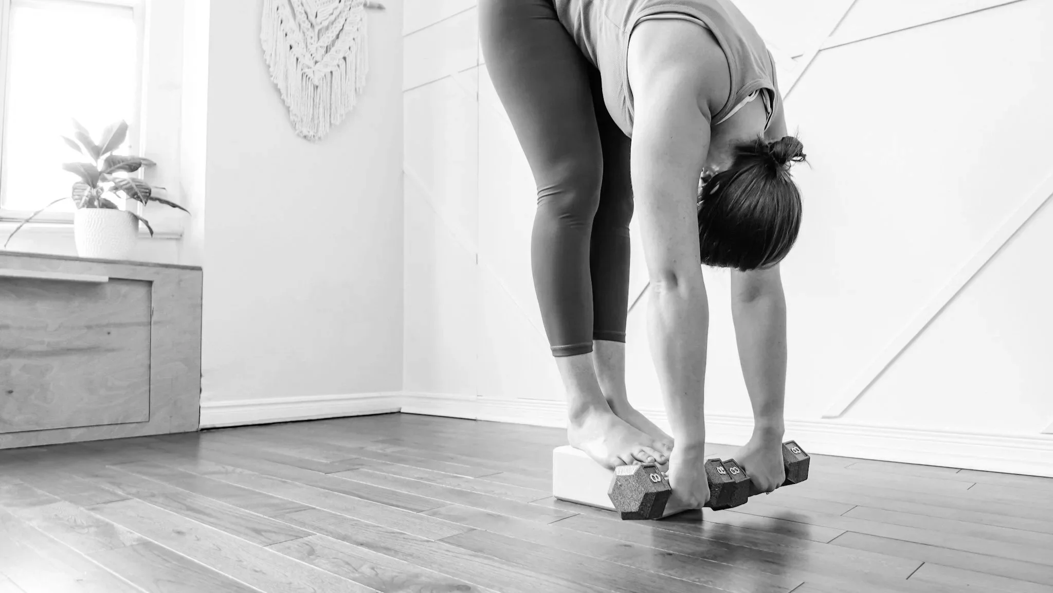 tanding forward fold Pilates movement improving flexibility and mobility in a Toronto studio