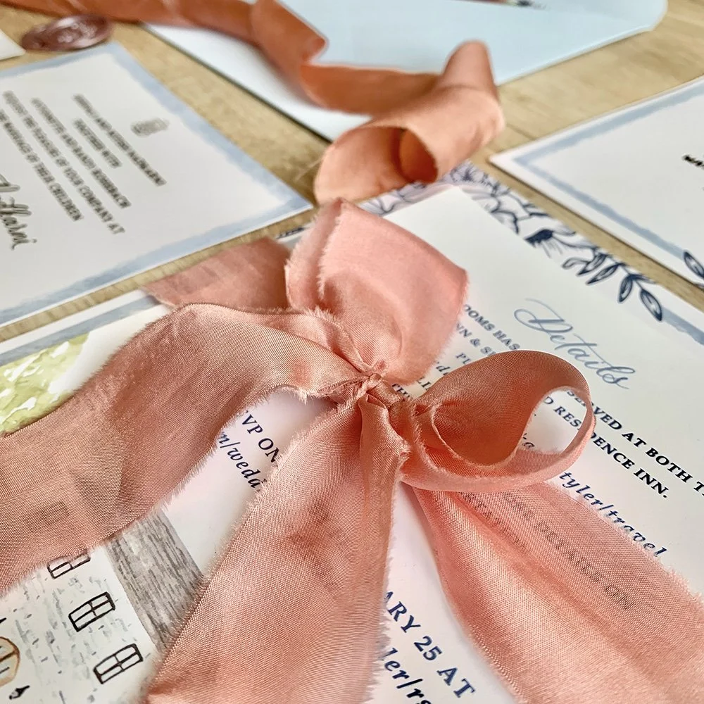 Macro shot of bespoke wedding invitation with hand torn silk ribbon with a big bow for a luxury indian american wedding.