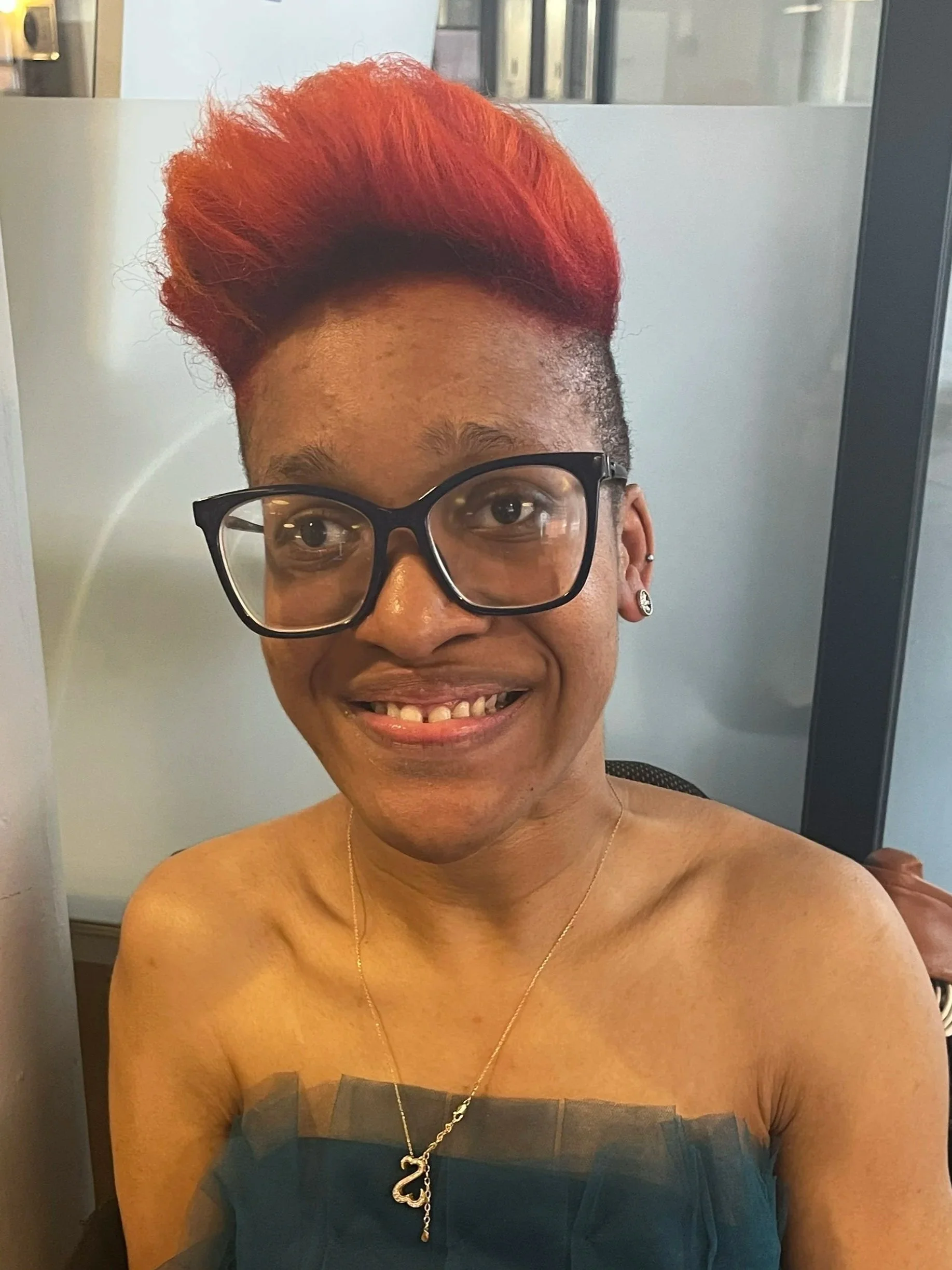 A young Black woman with braids and glasses.