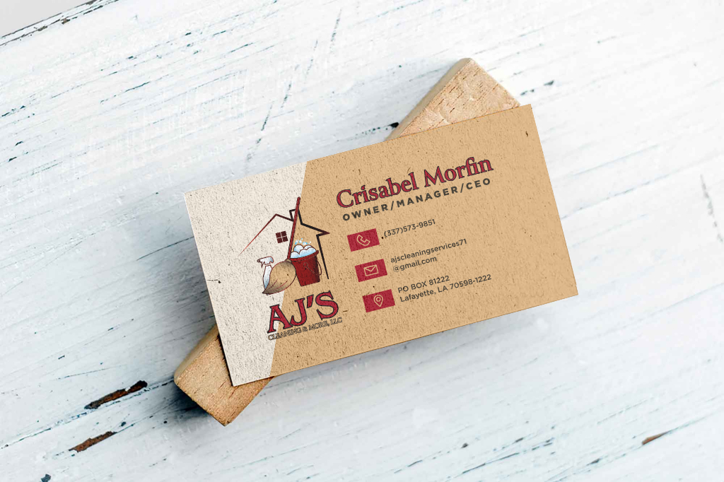 Business card for AJ's Cleaning & Mobile LLC with contact info, featuring a cartoon house and cleaning supplies on a wooden surface.