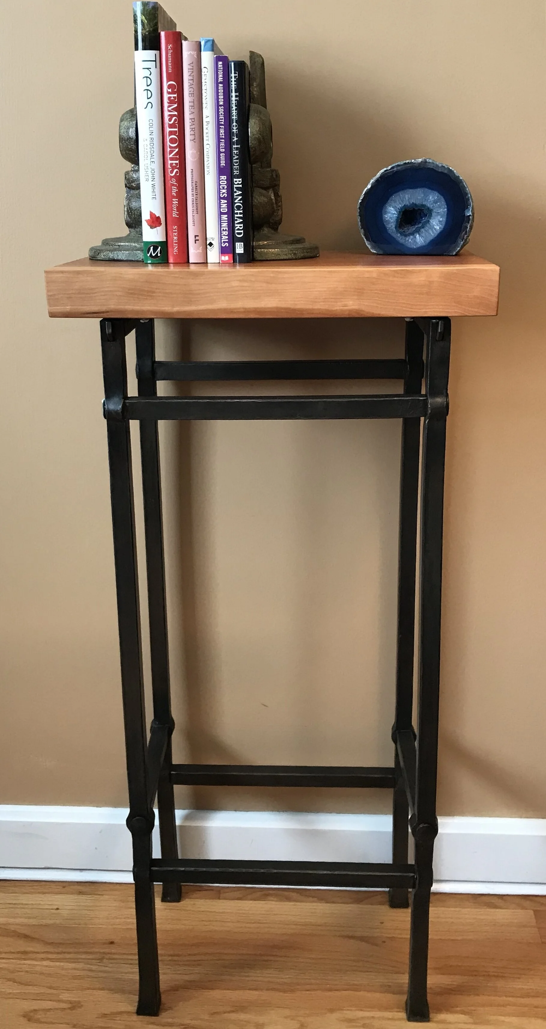 Cherry live edge entry table with hand forged mortis and tenon joinery. Finish: cold blued/beeswax