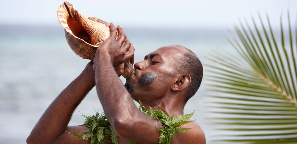 Man Blowing Conch Shell