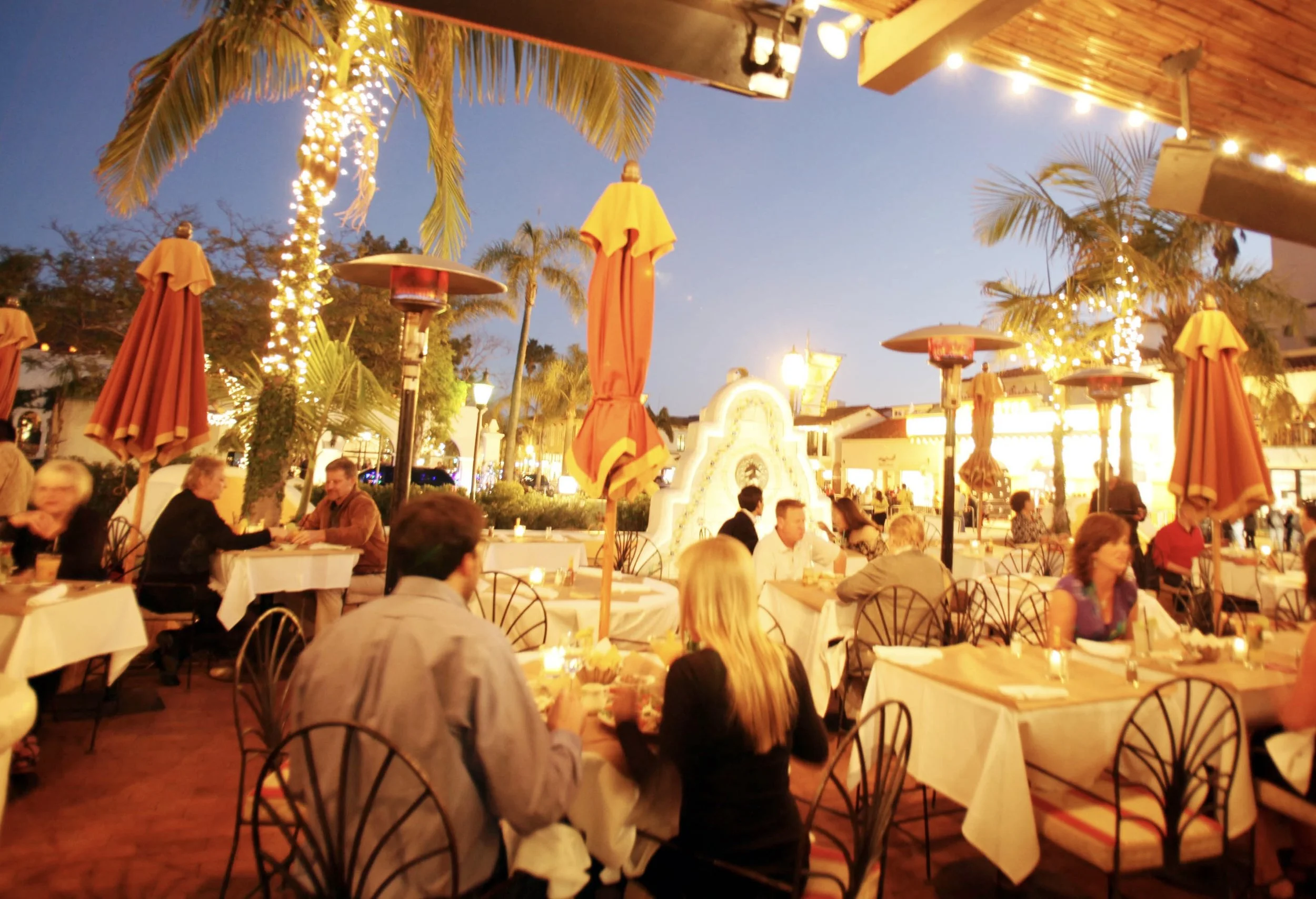 People having dinner, margaritas and cocktails on the front patio under the twinkling lights of Arlington plaza