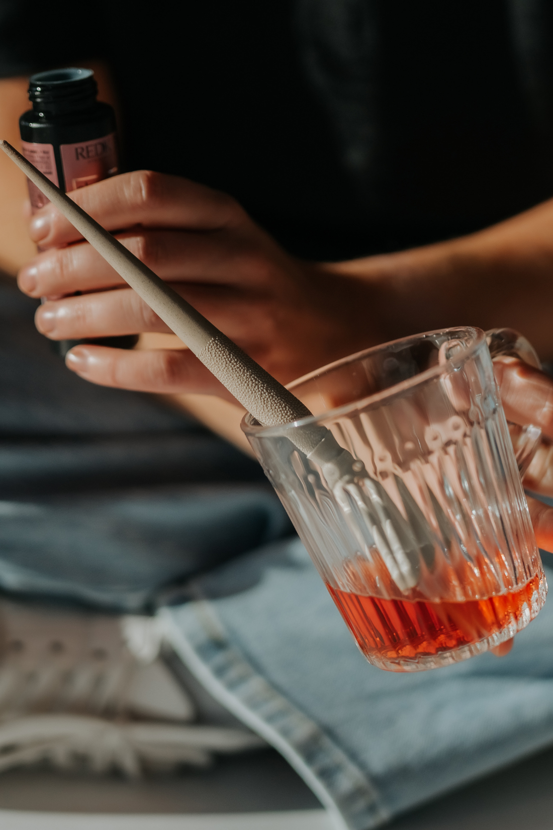 Pink gift box with a black hair tool and metallic star-shaped confetti inside and scattered outside.