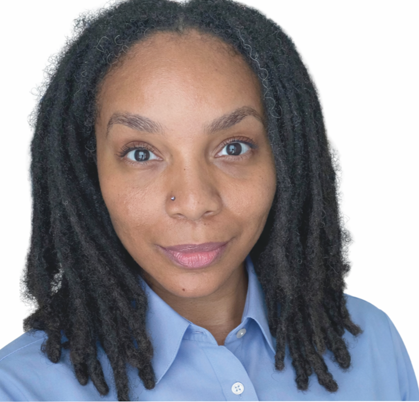 Portrait of a woman with dreadlocks, wearing a light blue collared shirt, and a nose piercing, smiling slightly.