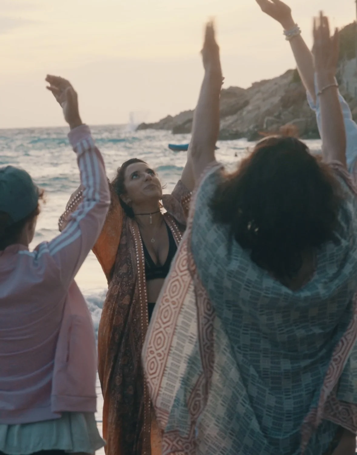 Bella guiding a healing movement meditation for Imbolc with a group of meditators by the Ocean in Ibiza