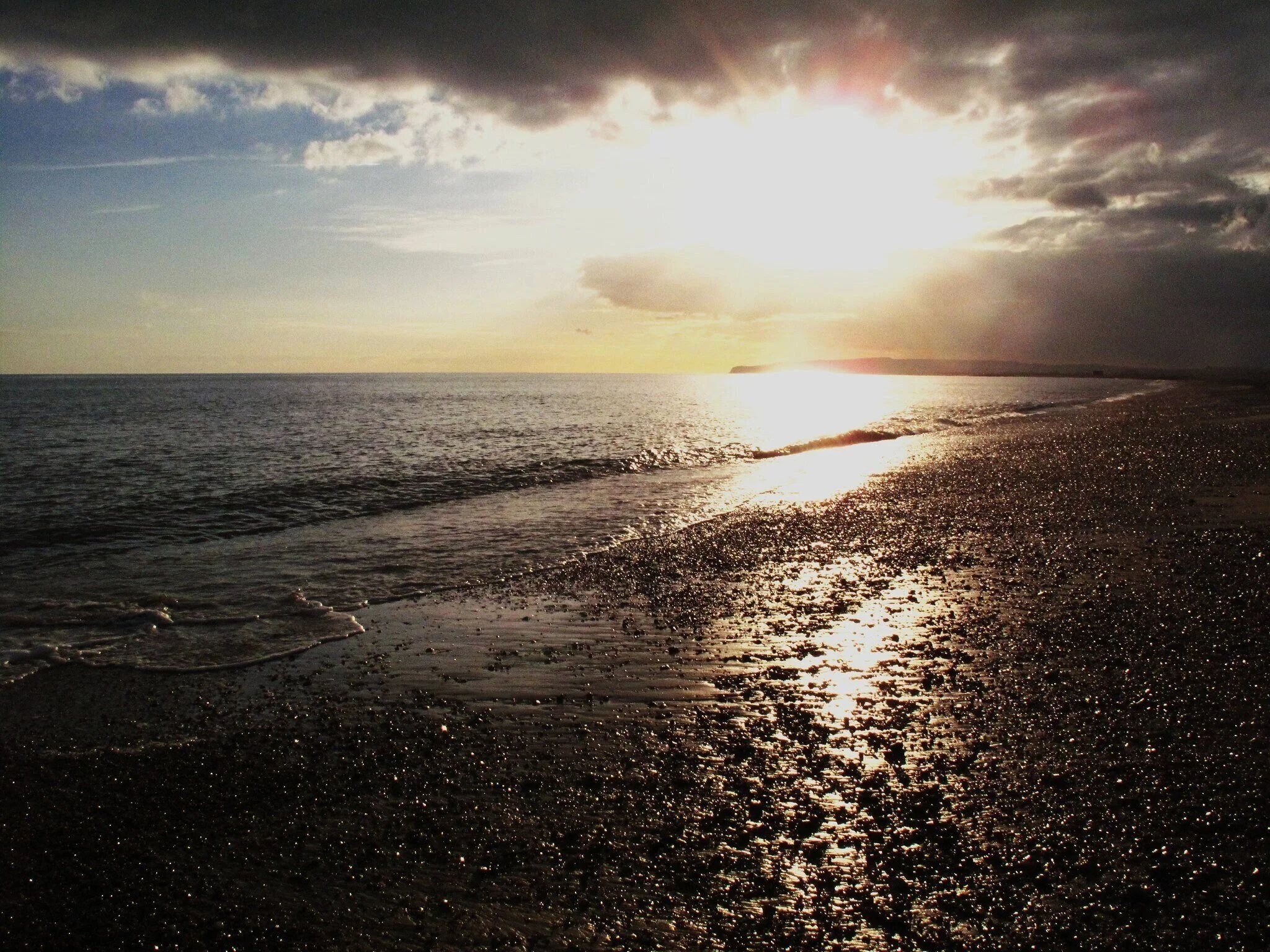 A photo of a beach at sunset, taken by Jo Matthews as part of her 'Sunlight Later' collection