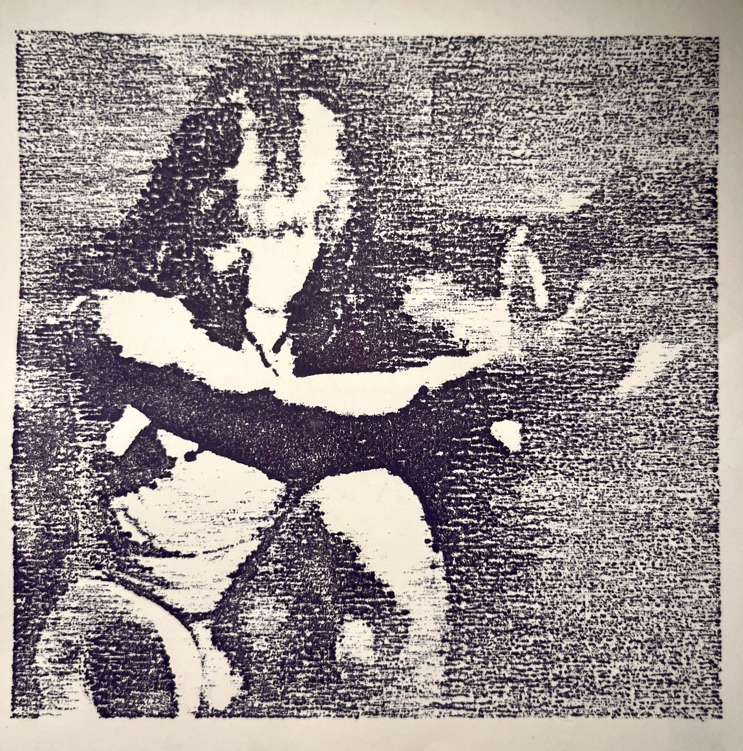 Black and white photo of a person standing on a beach holding a stick
