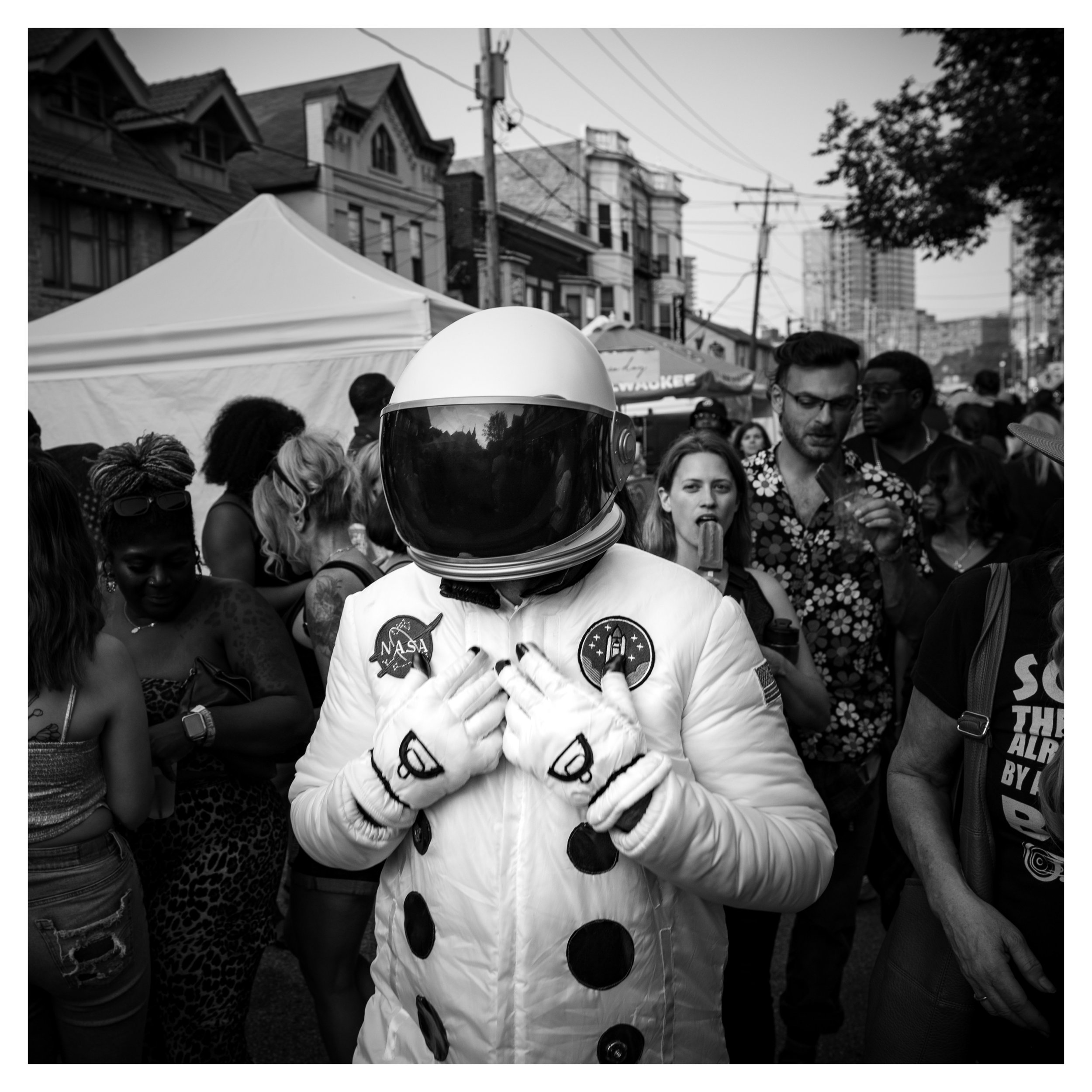 black and white street photo of a person in a space suit in the crowd of people at Milwaukees Brady street days