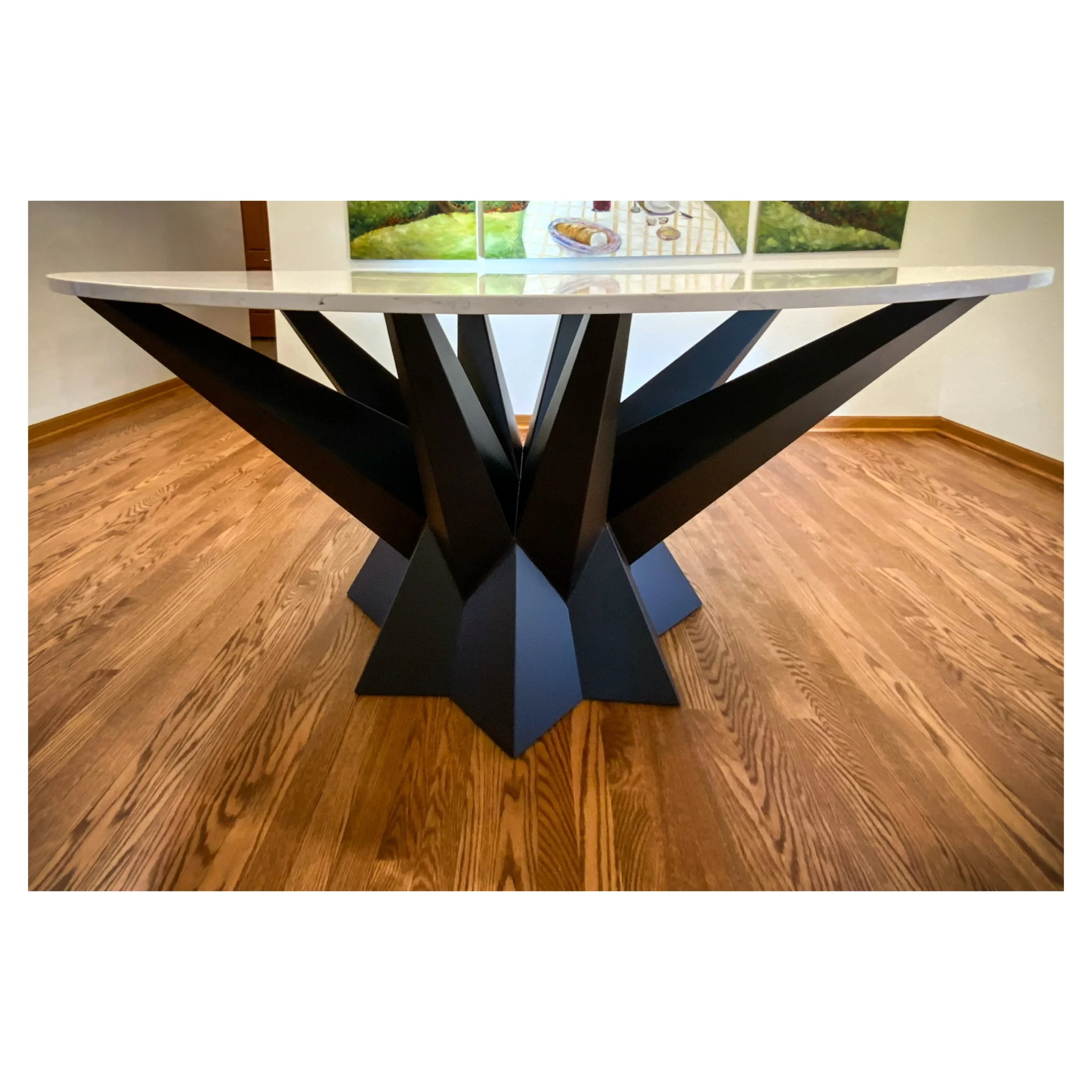 Black steel welded and bent multi facet angle table with granite stone top.  Table base has a starburst design that has a dramatic cantilever. 