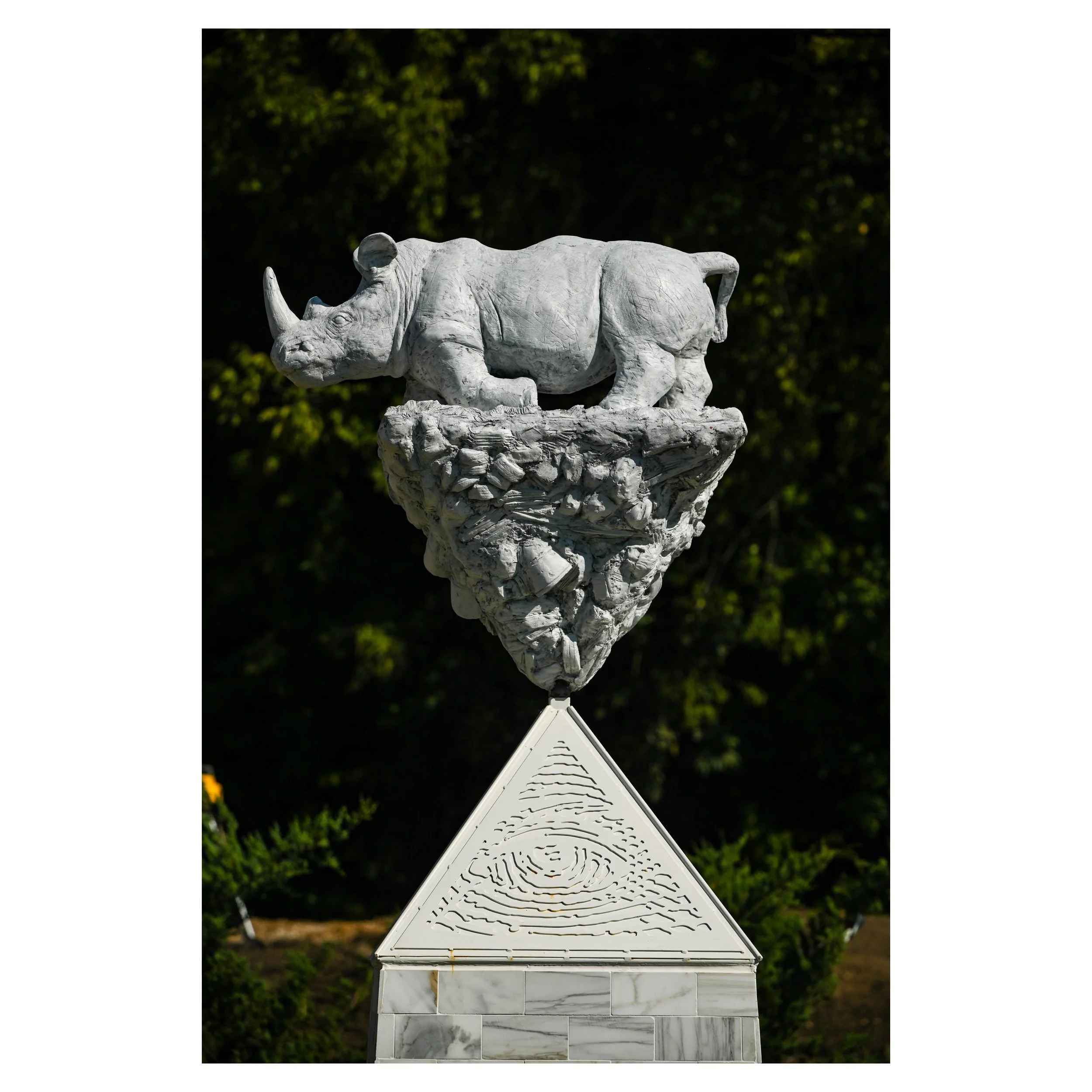 Close up detail of hand sculpted white rhino at the pinnacle of the sculpture Diminishing Returns.  The rhino is standing on a sculpted inverted pyramid of land polluted above every seeing eye 