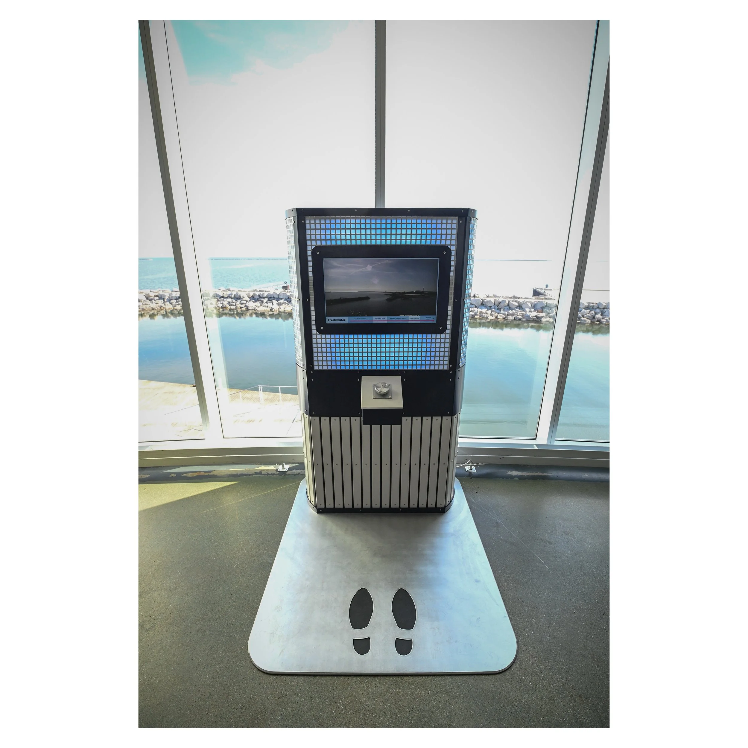 Discovery World kiosk overlooking Lake Michigan, made by Saint Louis studios, laser cut anodized aluminum foot prints and interactive kiosks with changing lights 