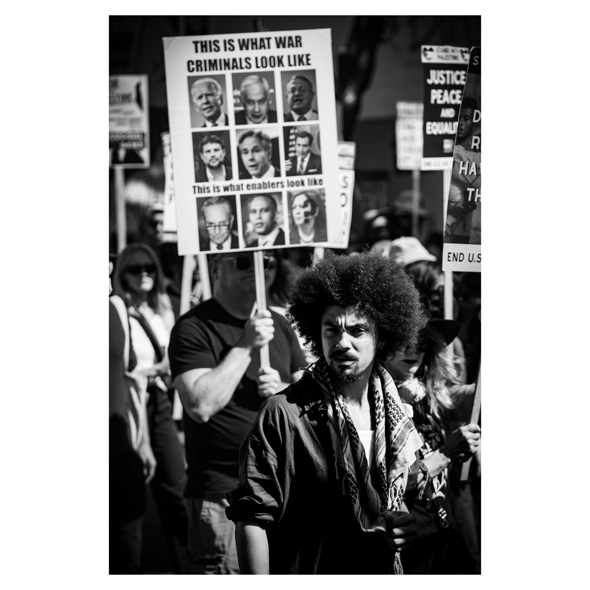 Street photo in black and white of protesters with signs at the Democratic National Convention in Chicago. 