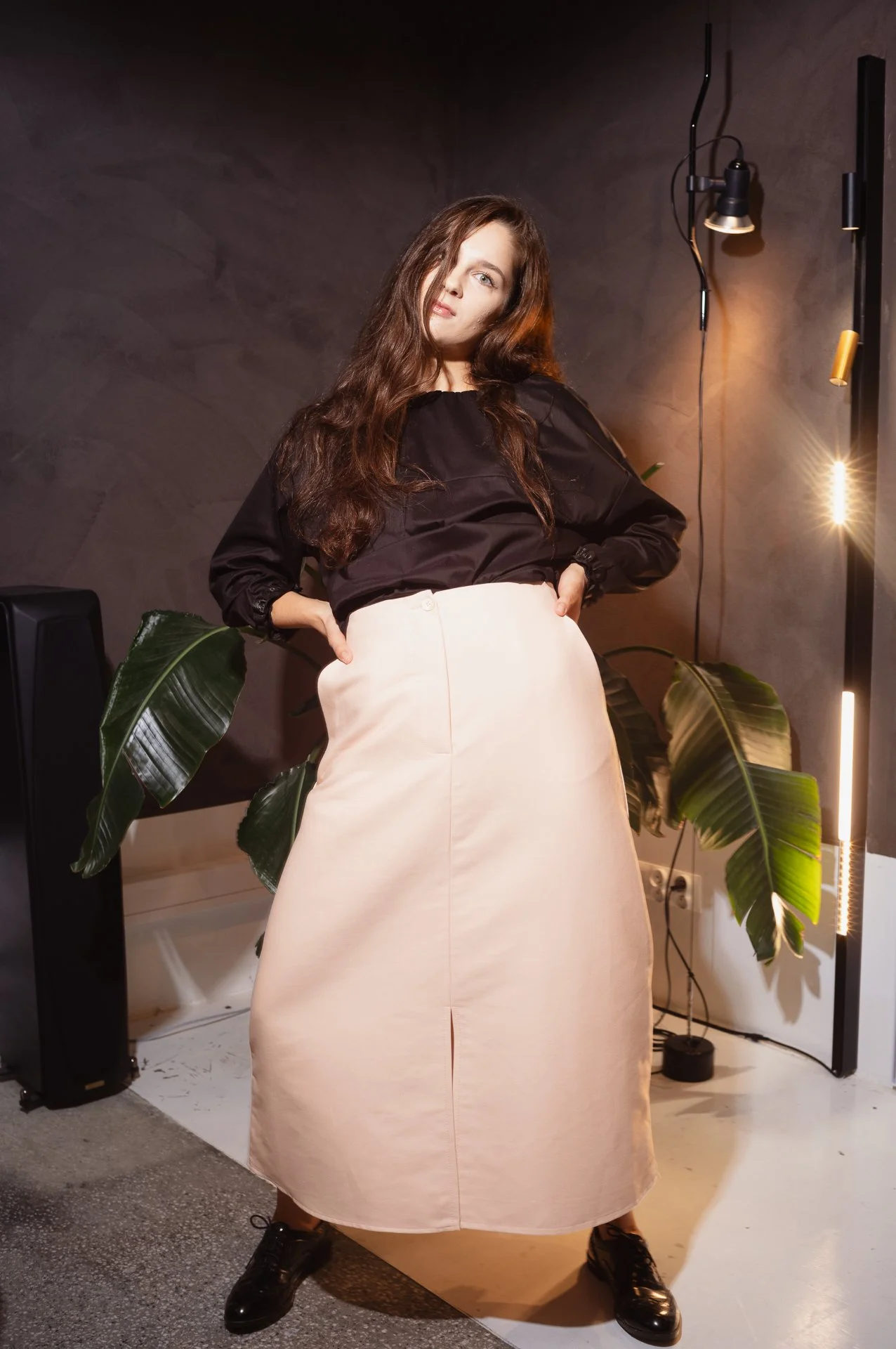 Fashion model posing indoors with contemporary decor and plant