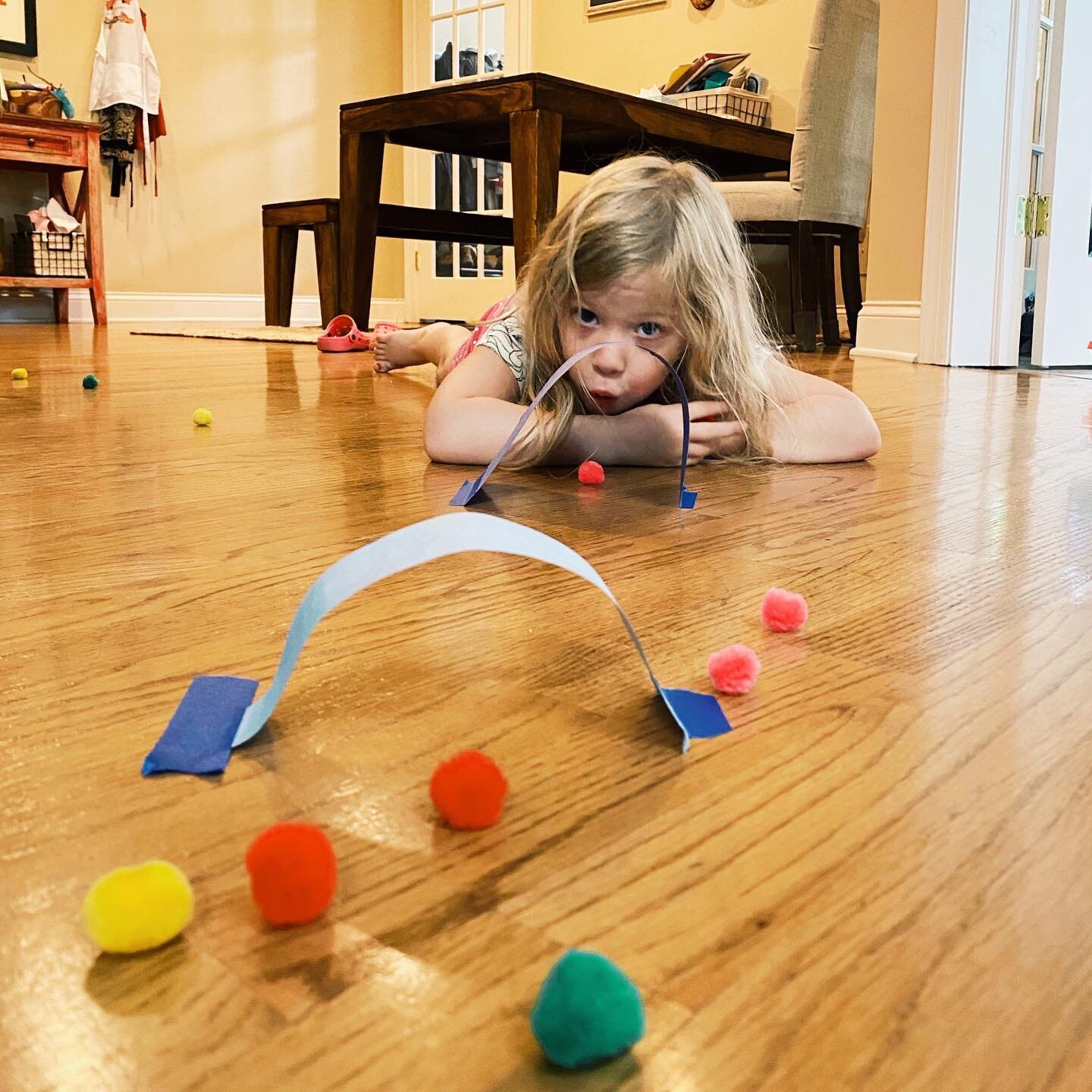 Kids getting overwhelmed with e-learning? Try this brain break breathwork activity. 
.
Cut out strips of paper and tape to the floor to make paper tunnels. Have kids lie on their tummy and blow colored pom poms (cotton balls work too) through the tun