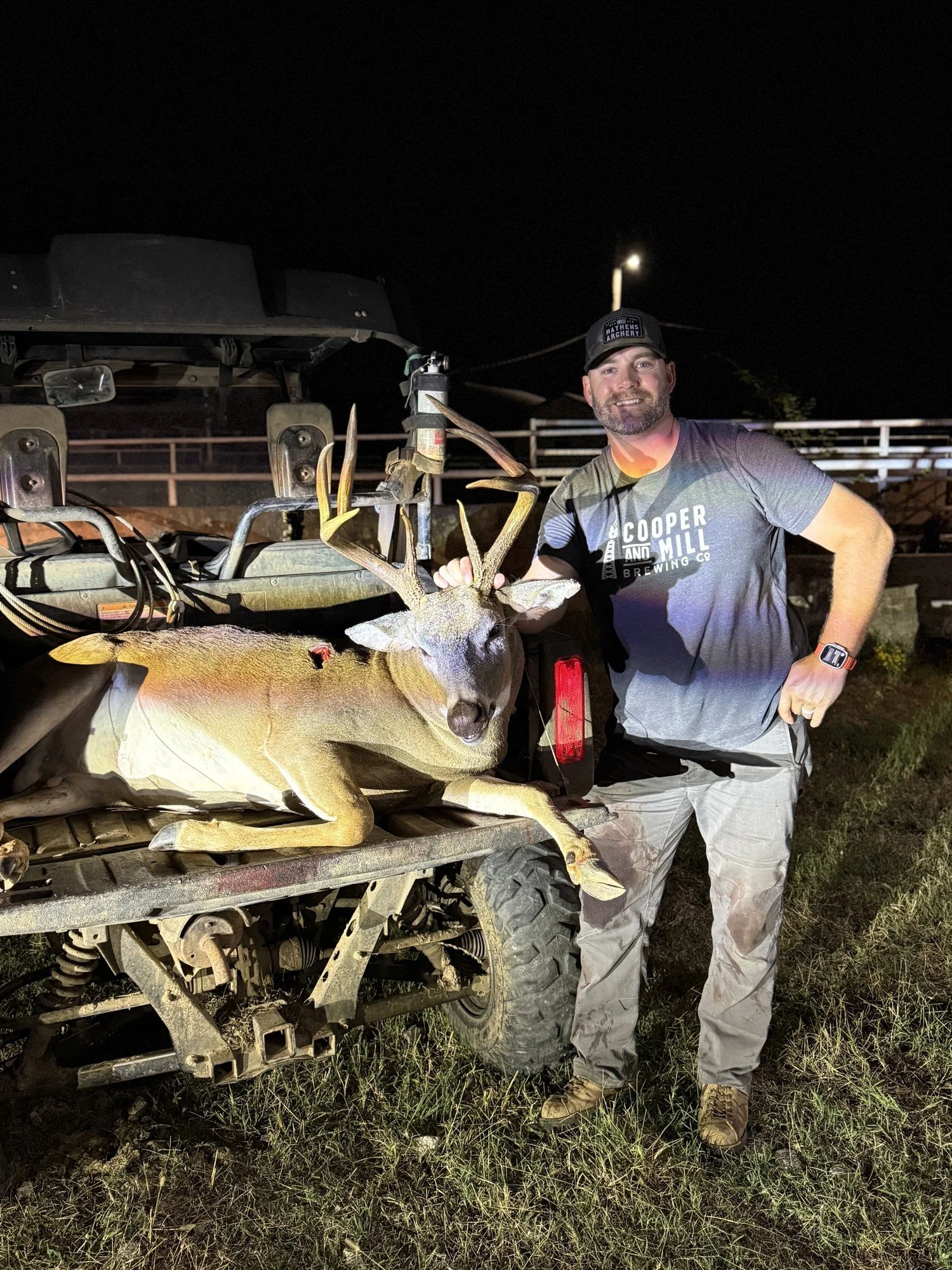 Matt with Tank, an eight-point buck, on the back of a side-by-side at night