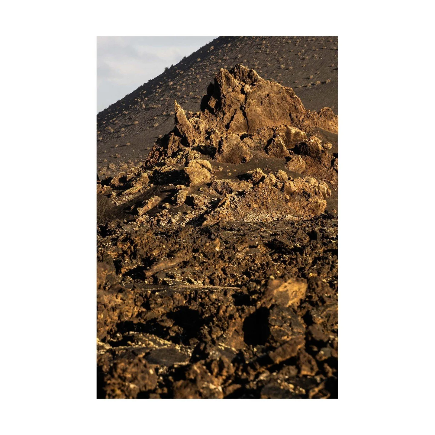 🌋 The Final Peak: Completing the Triptych 🌋
The last of the three volcanic formations stands tall, closing out the natural triptych created by the forces of Timanfaya. The sharp, rugged textures rise from the blackened lava fields, catching the lig