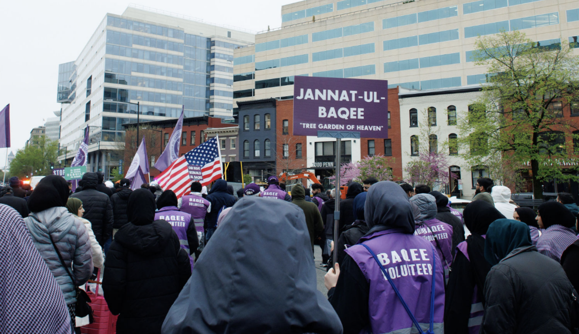 A large purple sign reading "JANNAT-UL-BAQEE 'TREE GARDEN OF HEAVEN'"