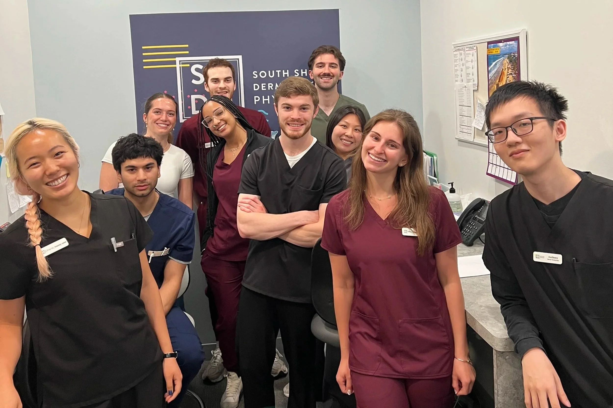Group of people wearing scrubs and smiling