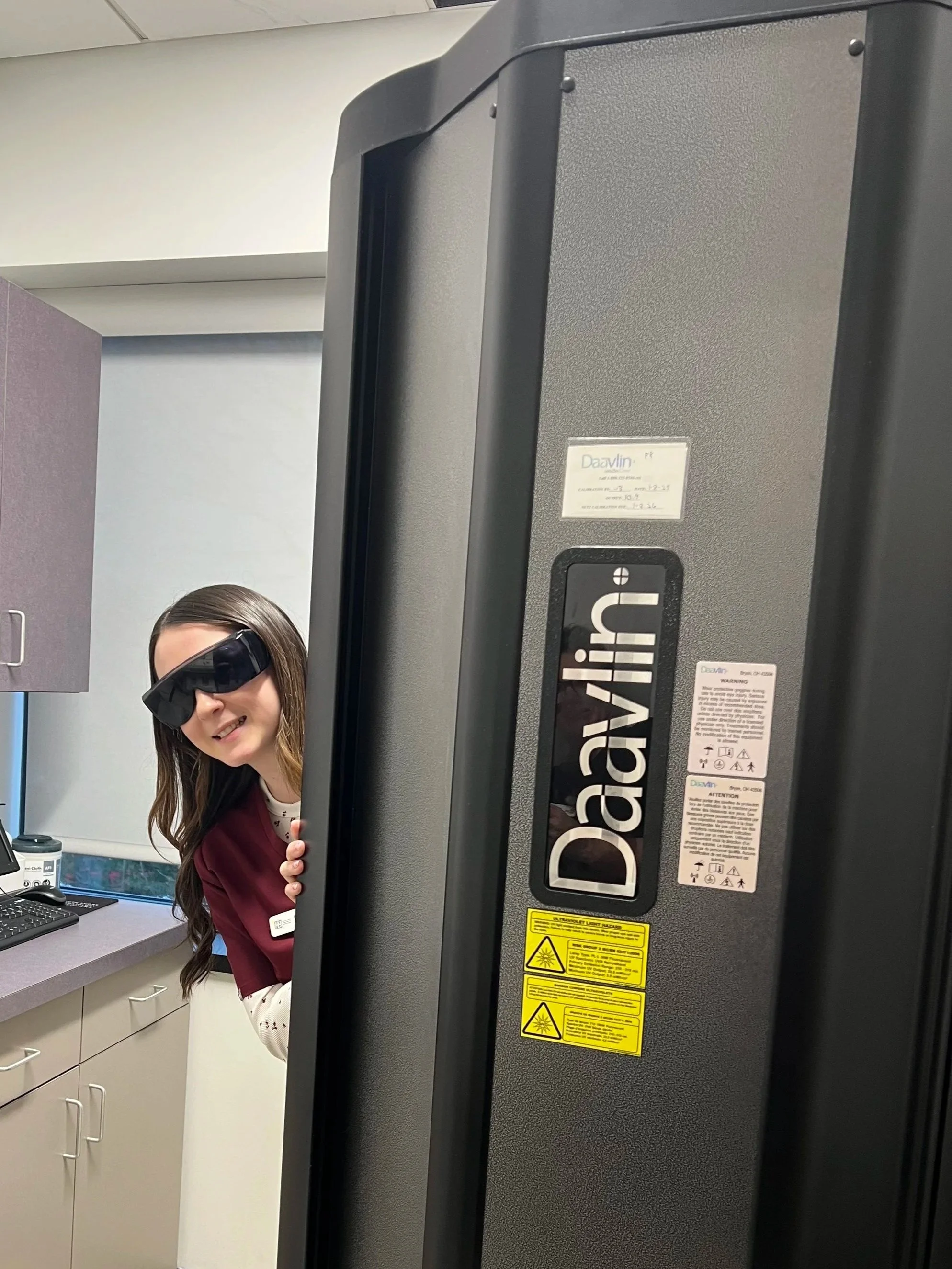 Nurse wearing protective eyewear with Narrowband Ultraviolet B (NB-UVB) phototherapy unit