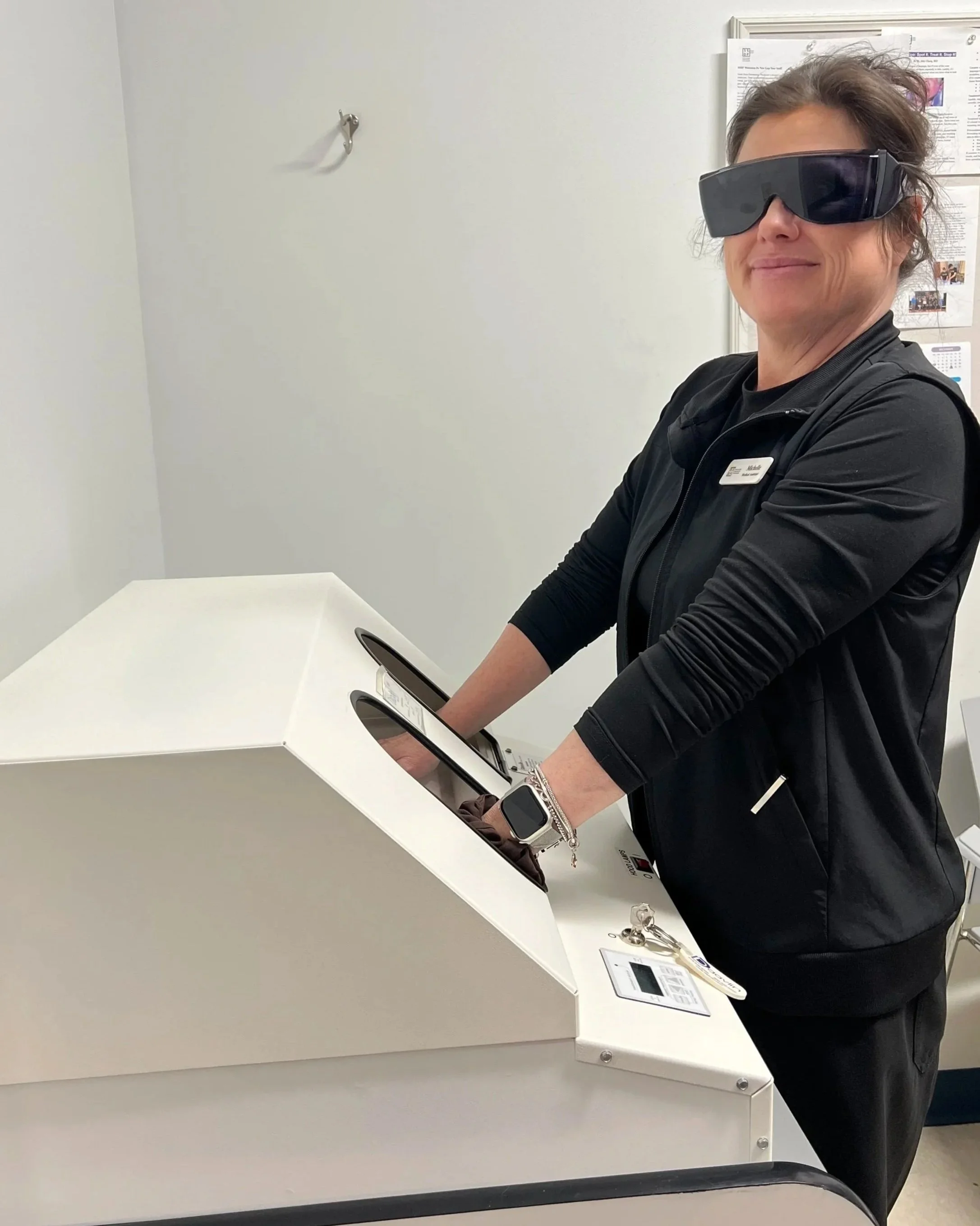 Medical assistant wearing protective eyewear with Narrowband Ultraviolet B (NB-UVB) phototherapy hand unit