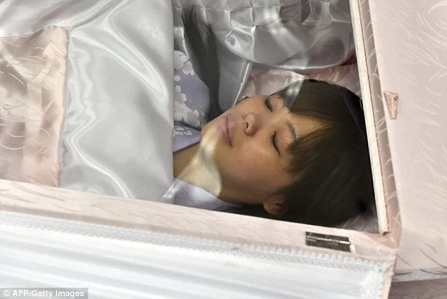 1410428979532_wps_8_A_woman_lies_in_a_coffin_.jpg