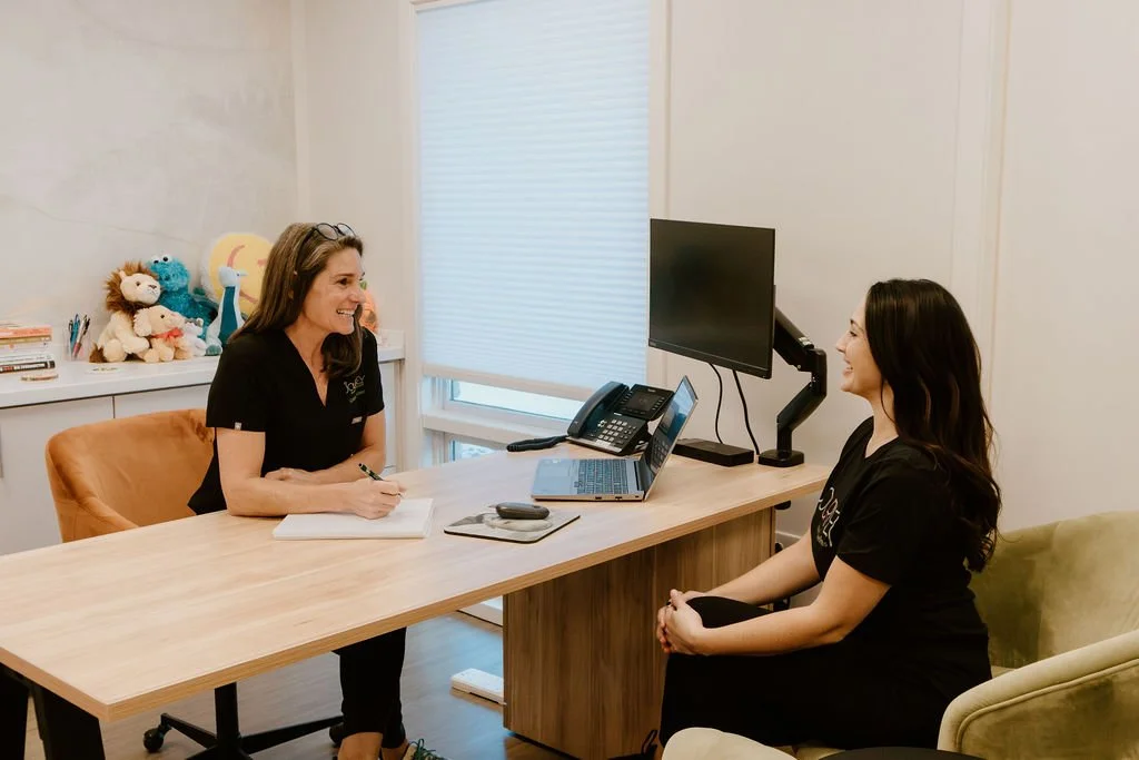 Holistic wellness consultation at Journey Health and Wellness with Kristie Geitner reviewing a personalized health and detox plan with a client.