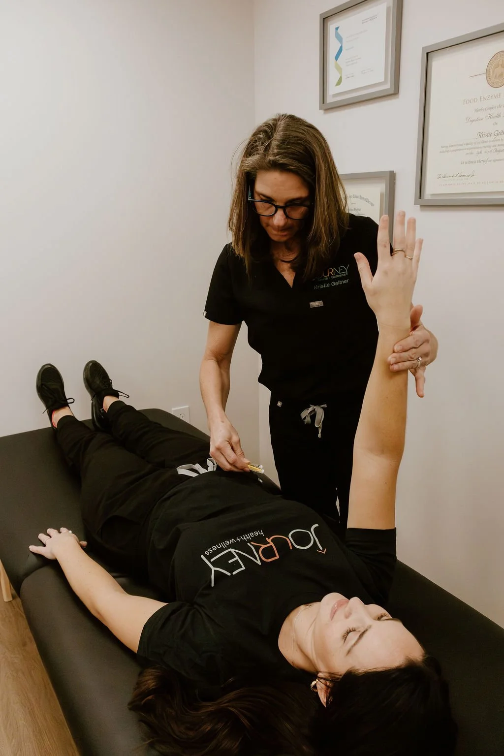 Practitioner using QNT muscle testing to evaluate toxin load and stressors as part of a holistic health consultation.