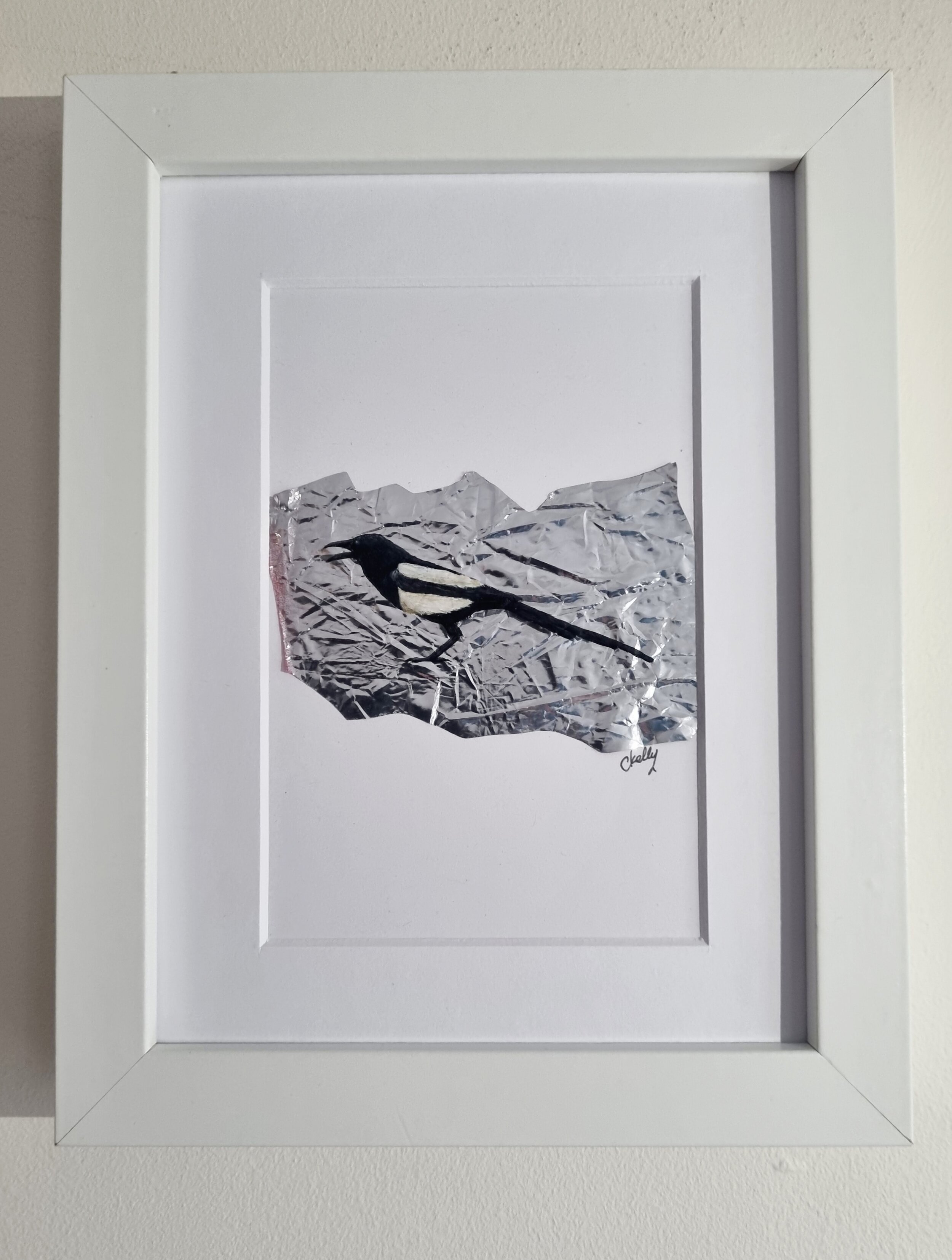 Framed image of a magpie painting on litter