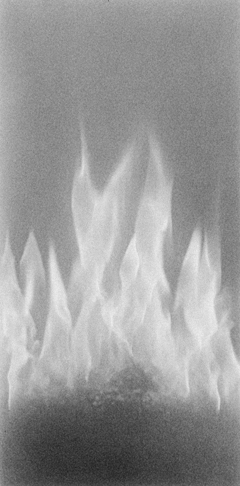 Grainy black and white close-up of flames, representing the persistent, low-grade burn of chronic inflammation in fertility care in North County San Diego