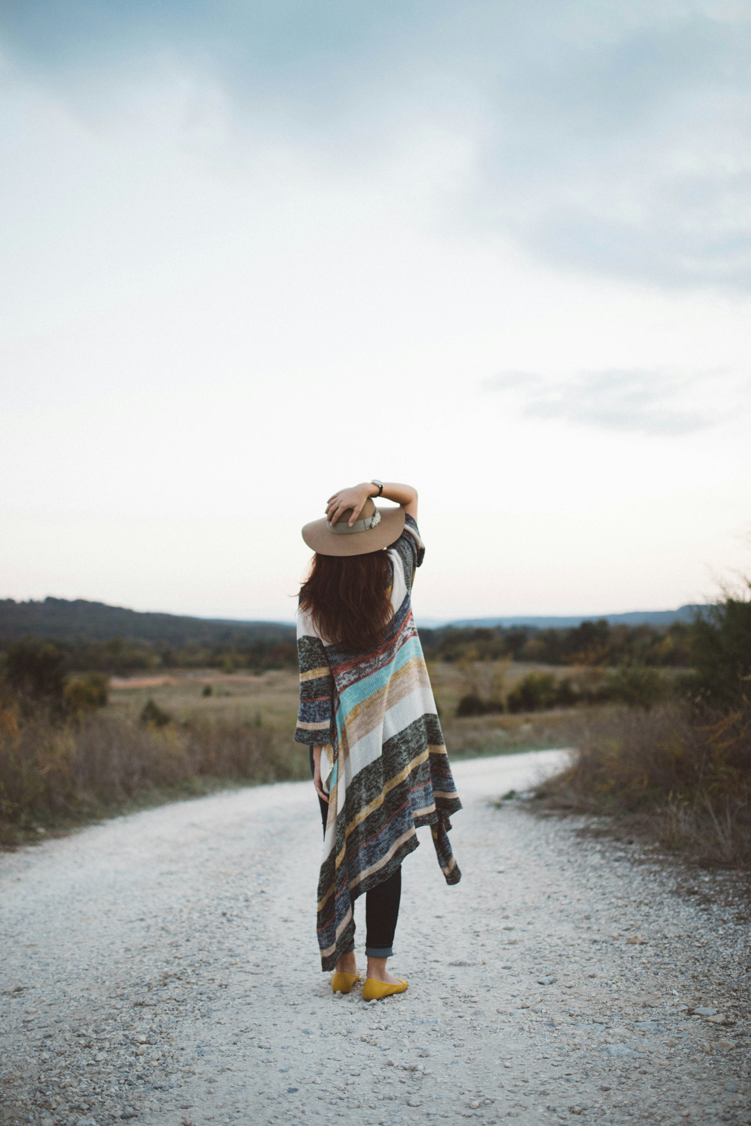 Woman gazing into the distance on a quiet road representing hope and direction in fertility care at Fertile Earth