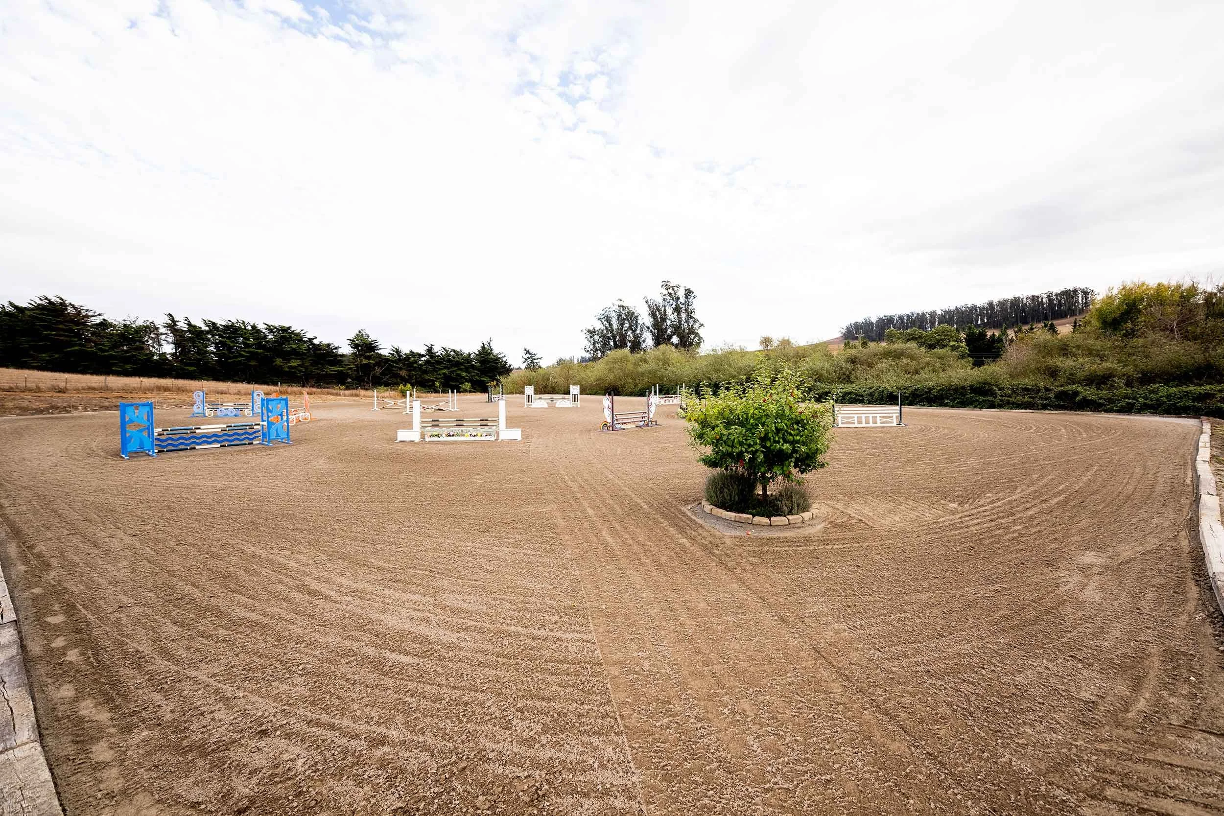 Outdoor arena set with colorful jumps