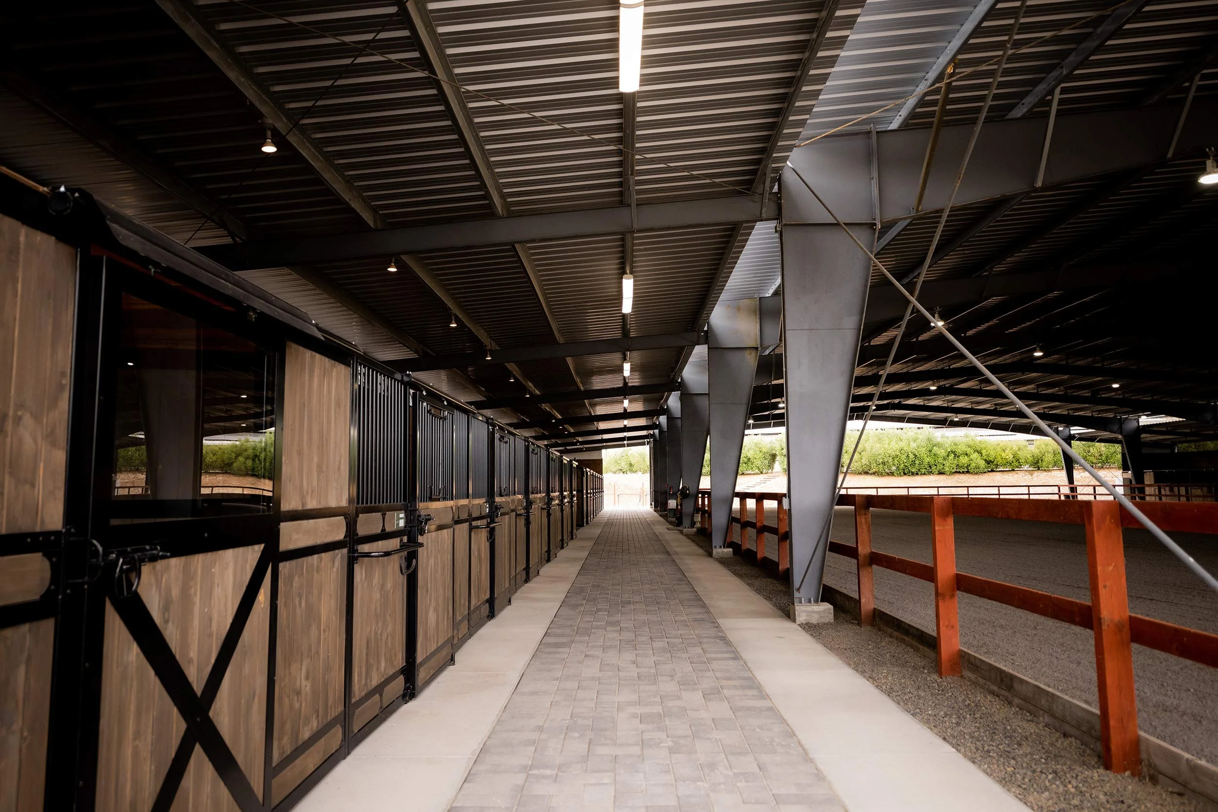 Barn aisle with stalls on the left and indoor arena on the right