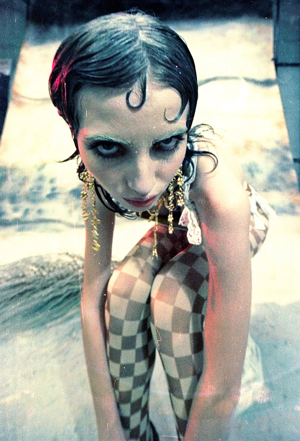 Model leaning into fish eye lens wearing Rosary earrings CLARK