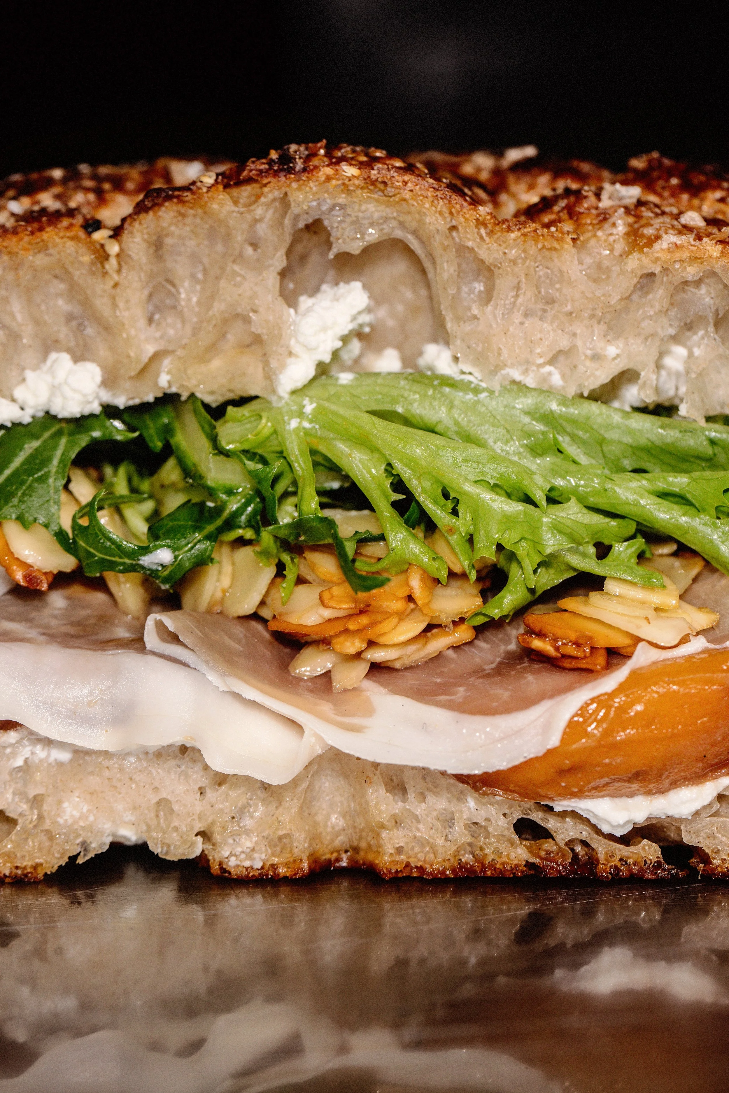 Homemade focaccia sando with Whipped ricotta, Parmaham roasted peaches, Almonds and McNallys Leaves