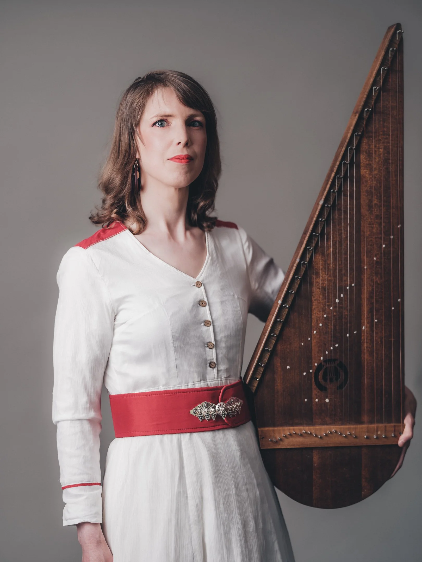 Profile Picture with arctic folkpop artist Mirja Palo and her Saarijärven Kantele wearing modern sami design dress by Sara Svonni. Photo by: Carl-Johan Utsi