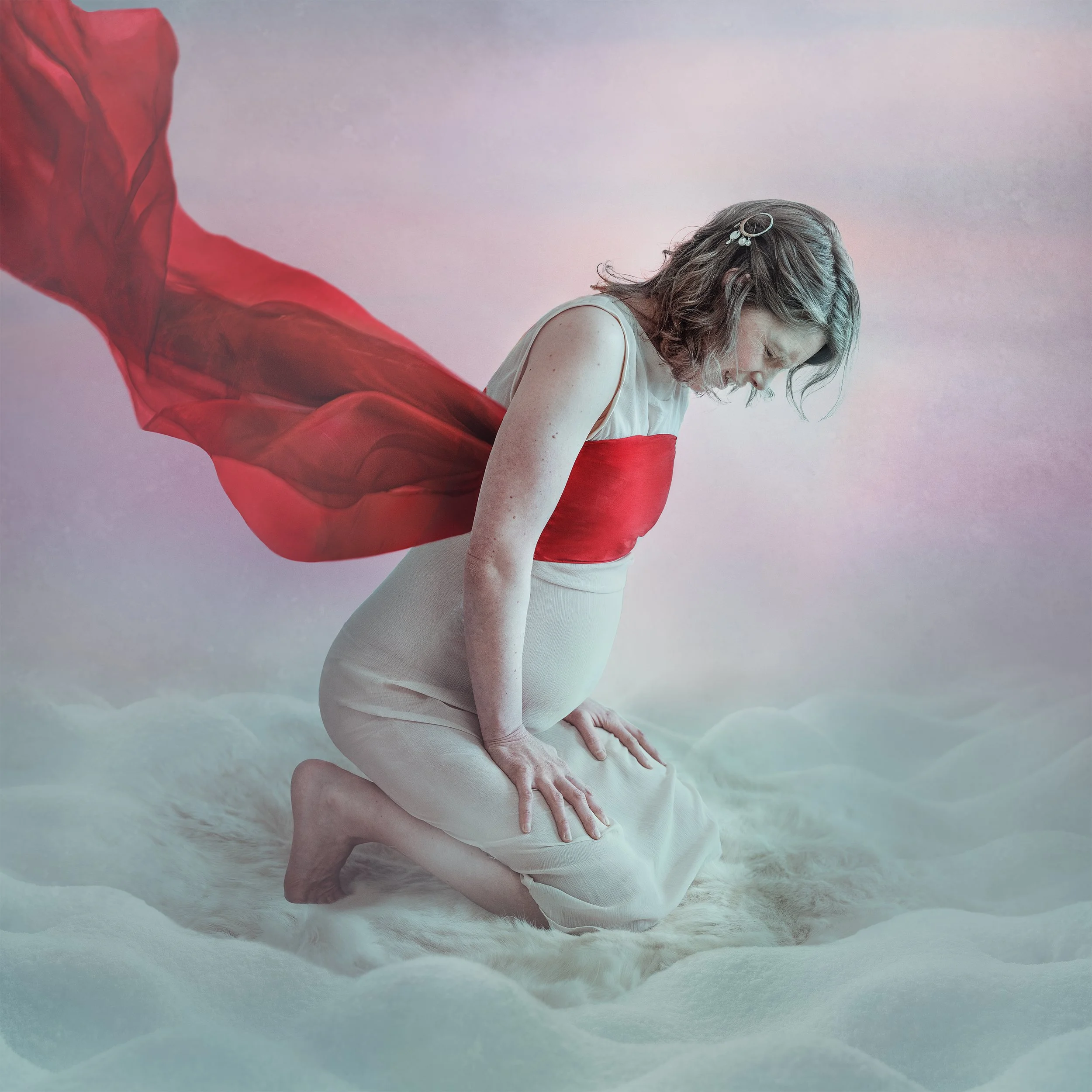 Arctic folk pop artist Mirja Palo, a pregnant woman in a beautiful dress, sitting on a soft white surface with red fabric flowing behind her. photographed by Lisa-Love Bäckman