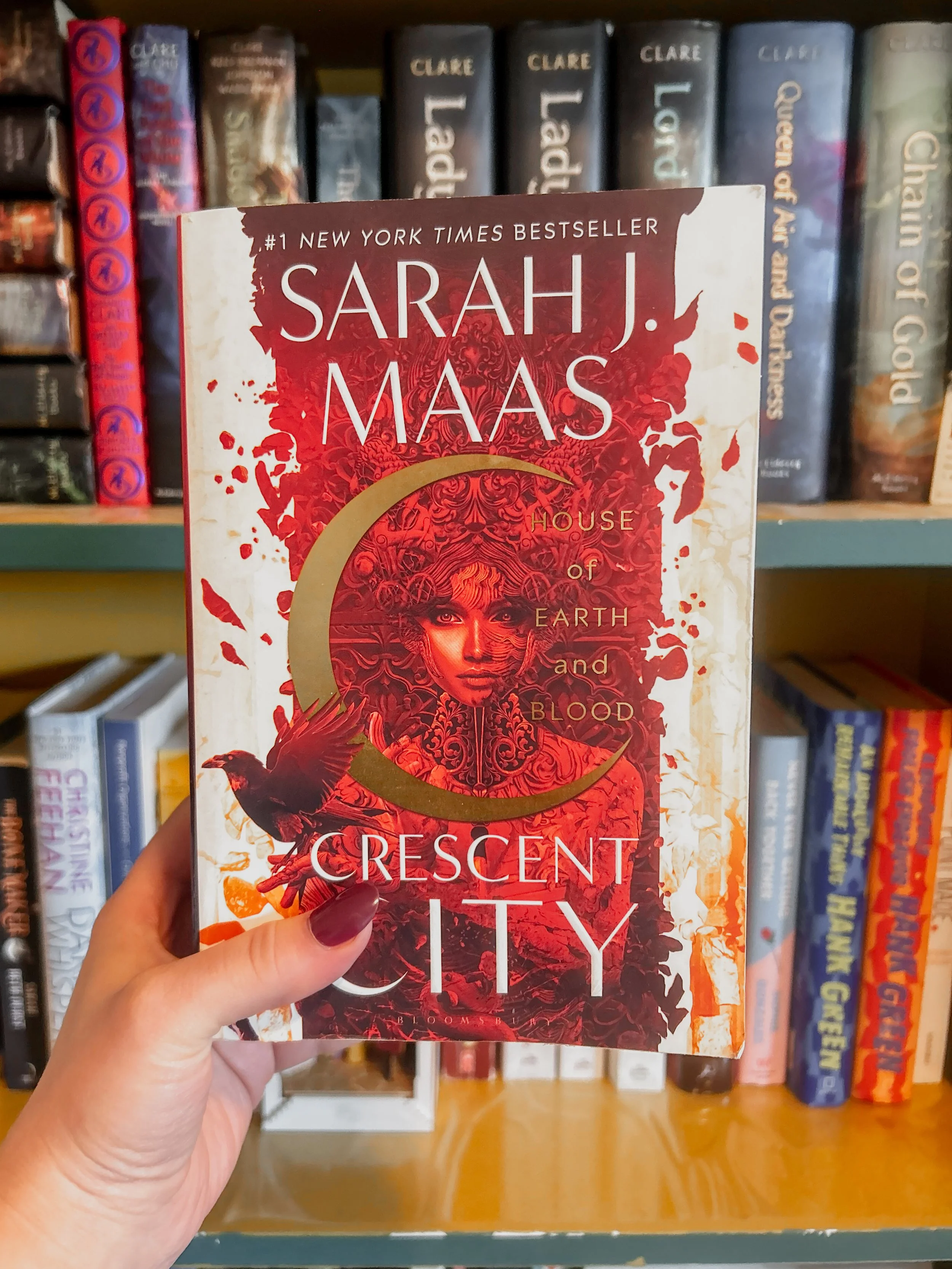 photograph of House of Earth and Blood by Sarah J. Mass in front of a bookshelf