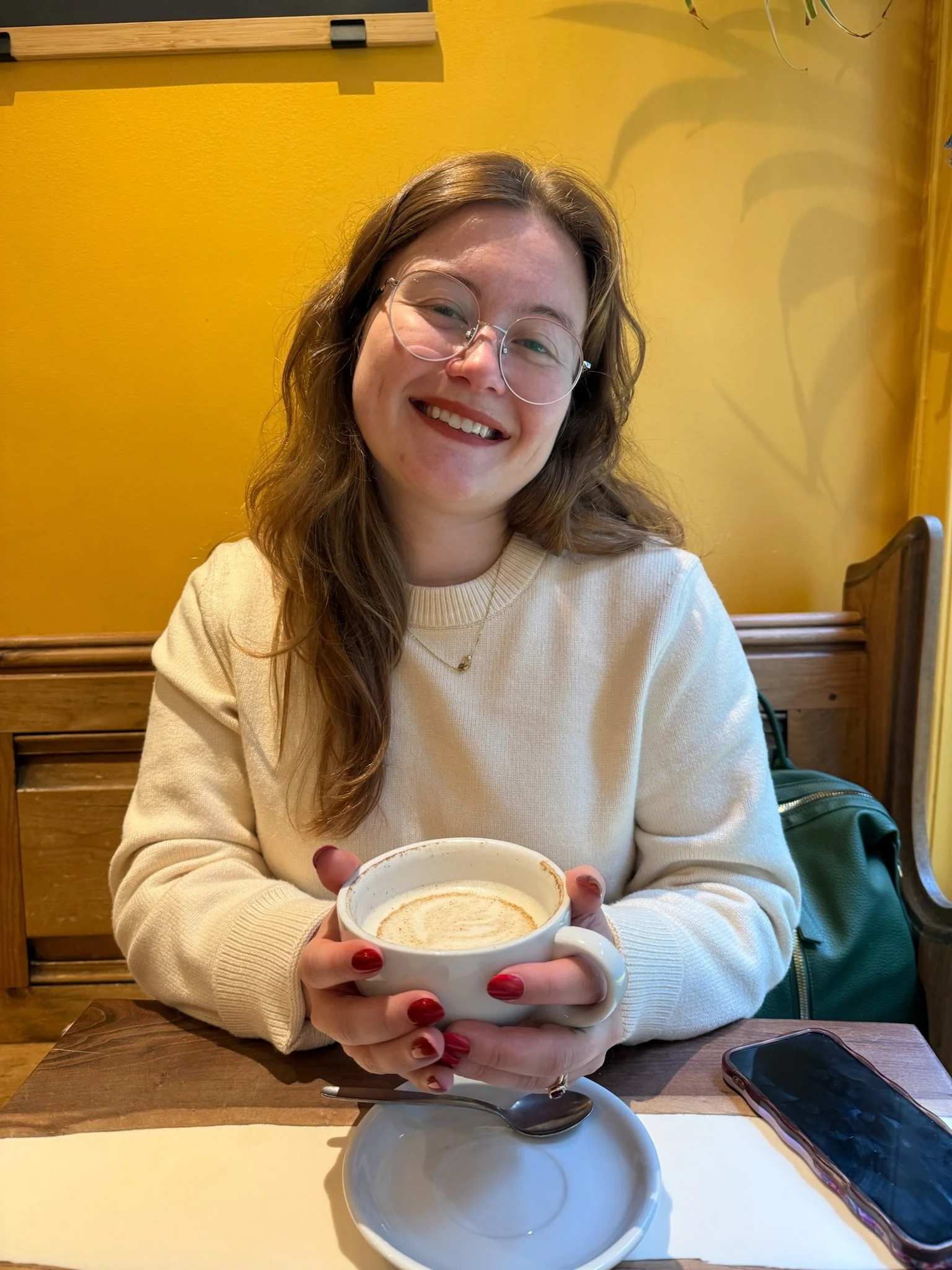 woman holding a cup of hot chai in a cafe