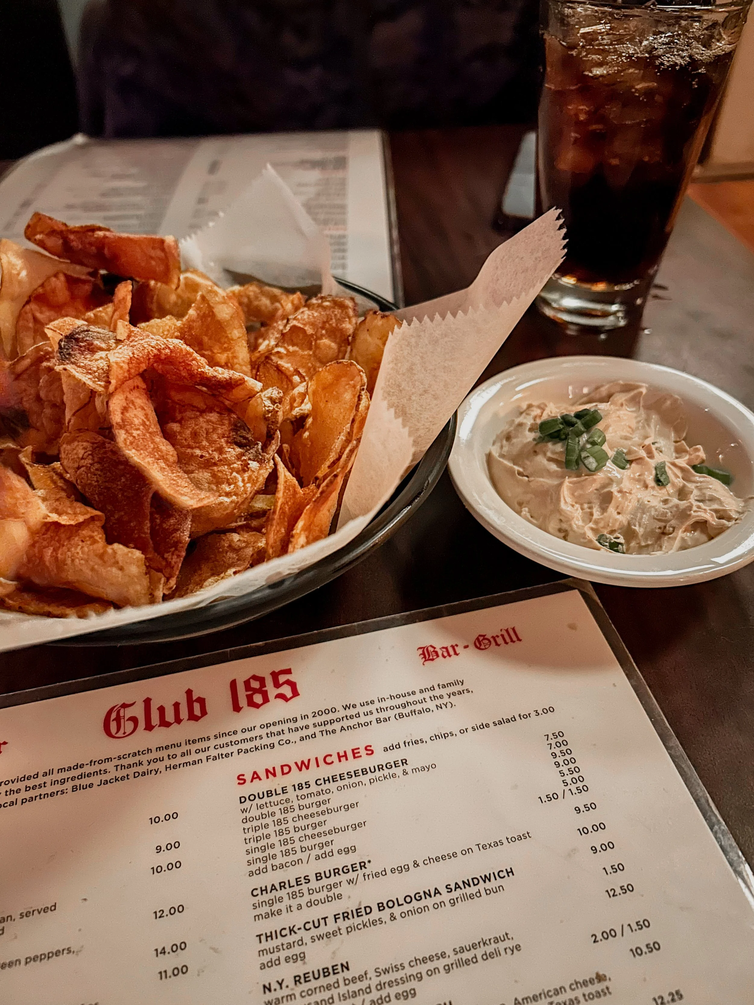table layout at Club 185 with a glass of coke and chips and dip