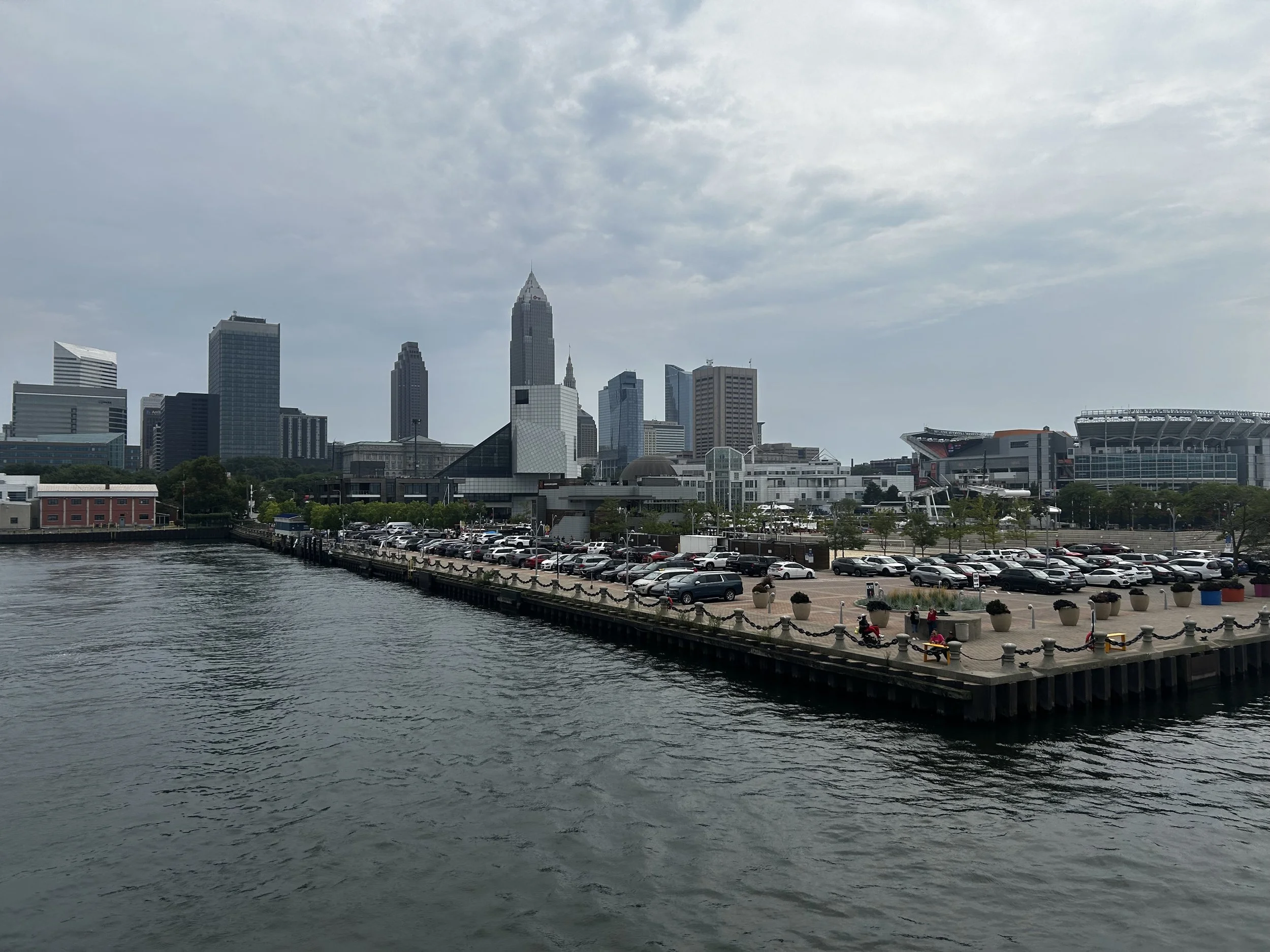 A photo of a dock on a large lake with the skyline of a large city in the background and blue skies