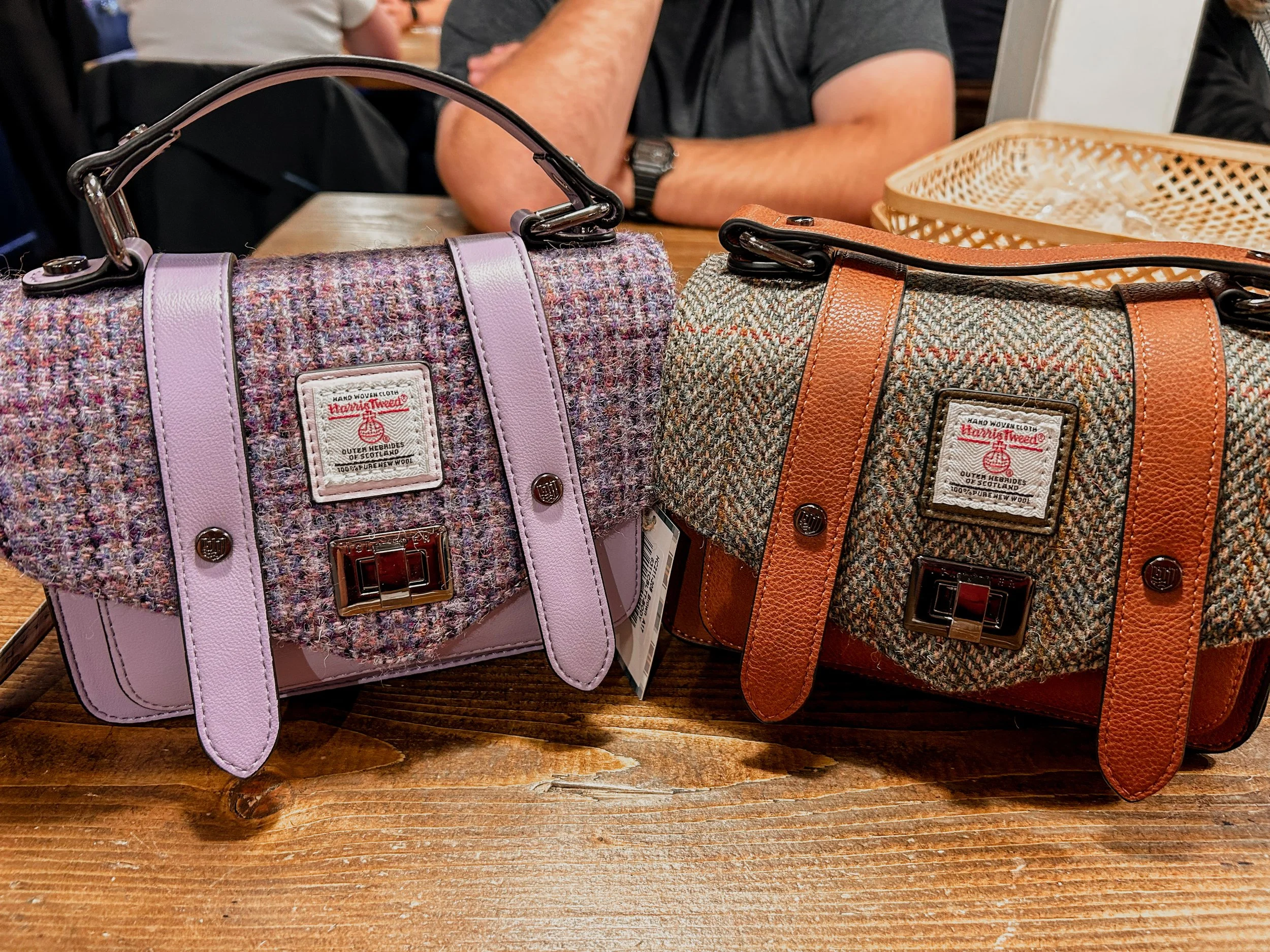 two leather and tweed purses on a table