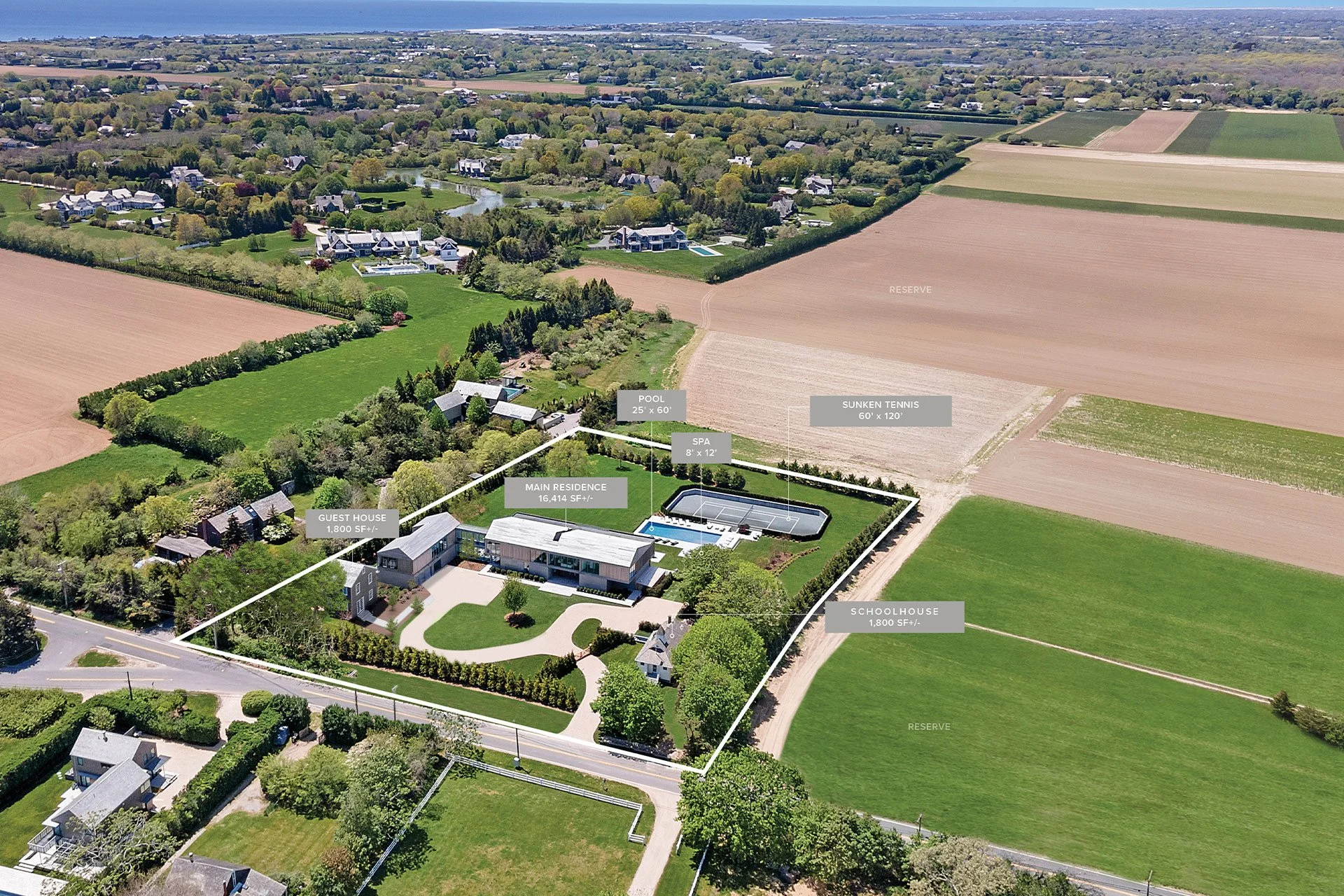 Aerial view of a large estate with a main house, guest house, schoolhouse, pool, tennis court, spa, and surrounding farmland labeled with measurements and descriptive labels.