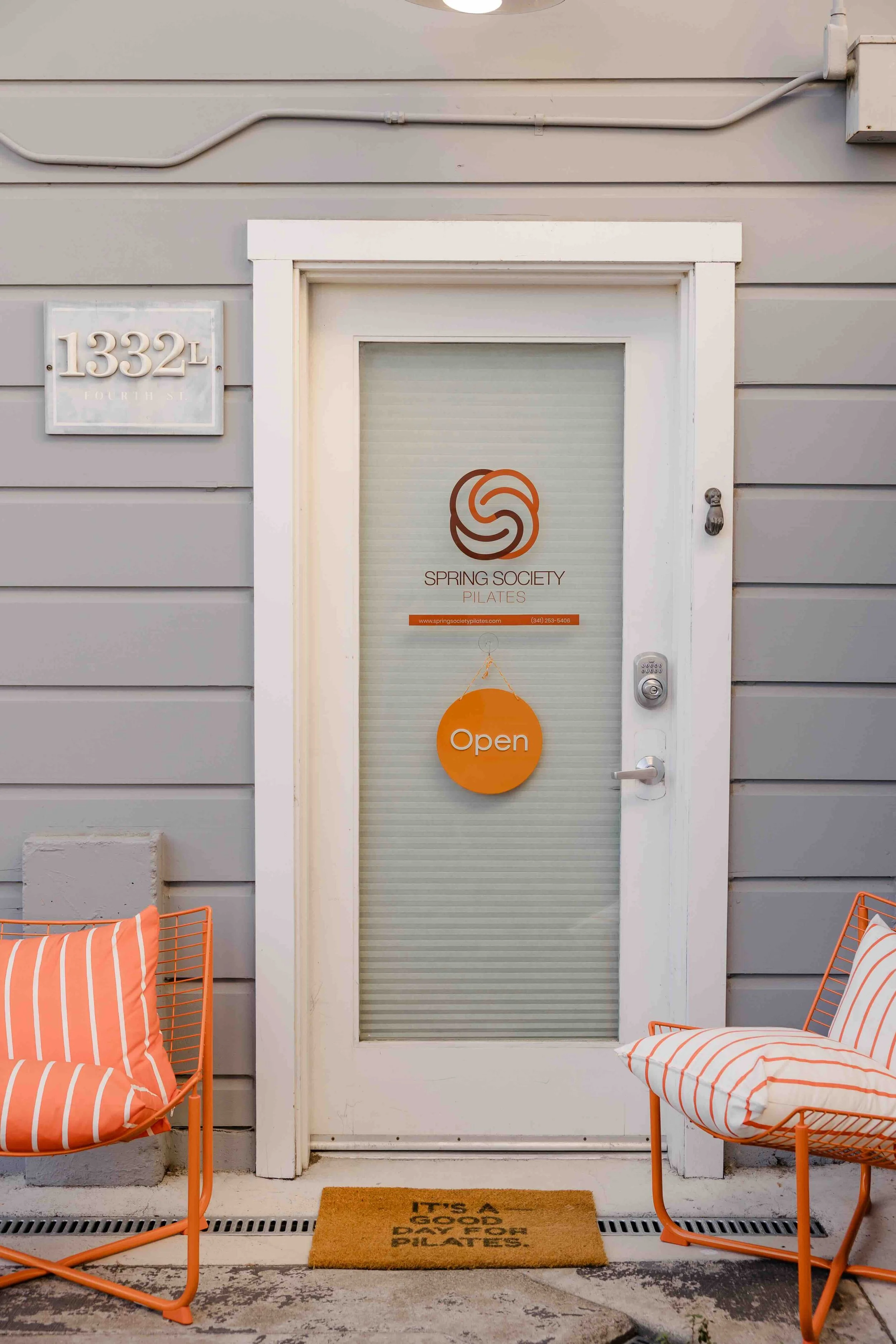 Spring Society Pilates front door with orange chairs in front