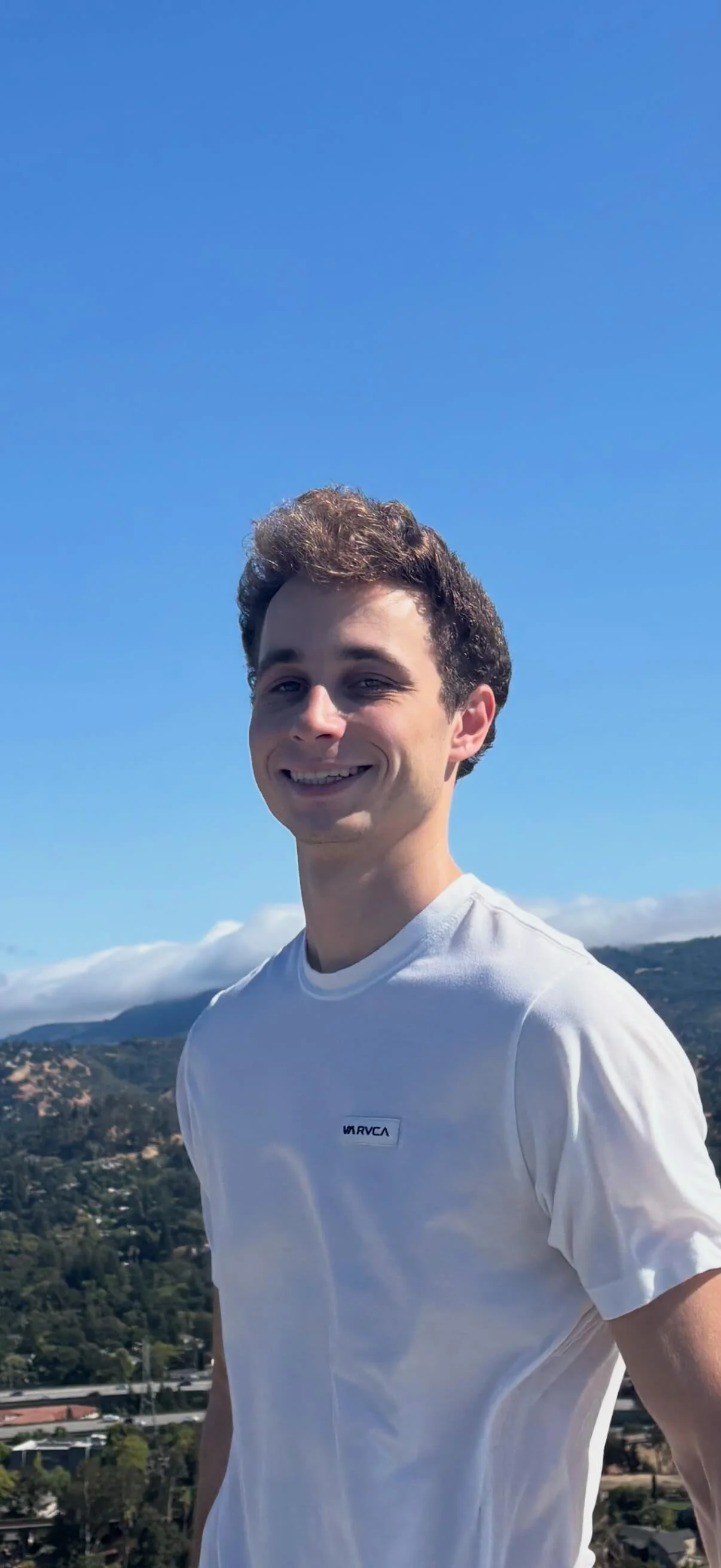 Alex Filonov, UC Berkeley Data Science and Business student and math tutor, wearing a white shirt under blue skies, specializes in Algebra, Geometry, Calculus, Statistics, SAT Math, and computer science tutoring